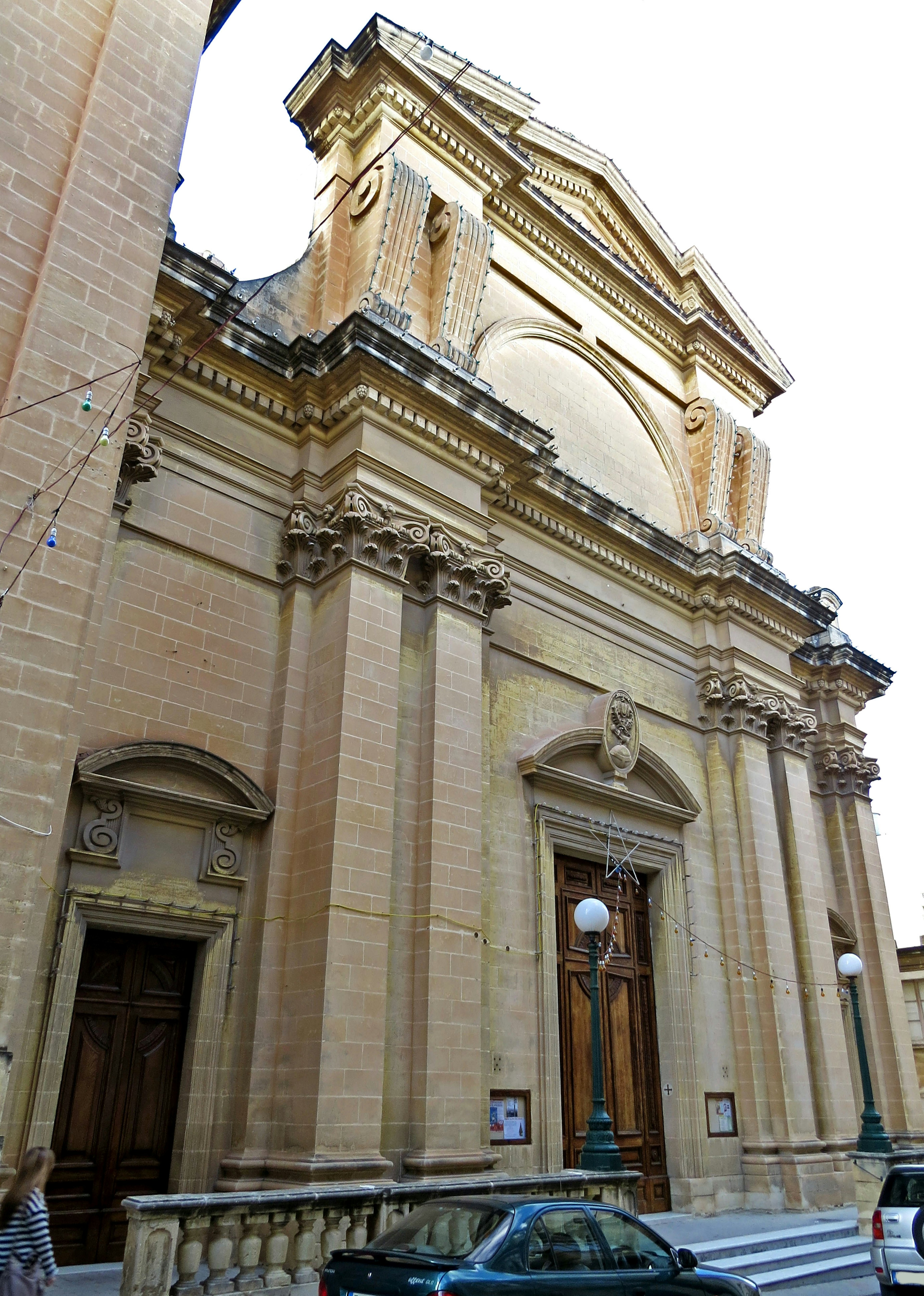 Außenansicht einer schönen barocken Kirche mit großen Holztüren und dekorativer Fassade