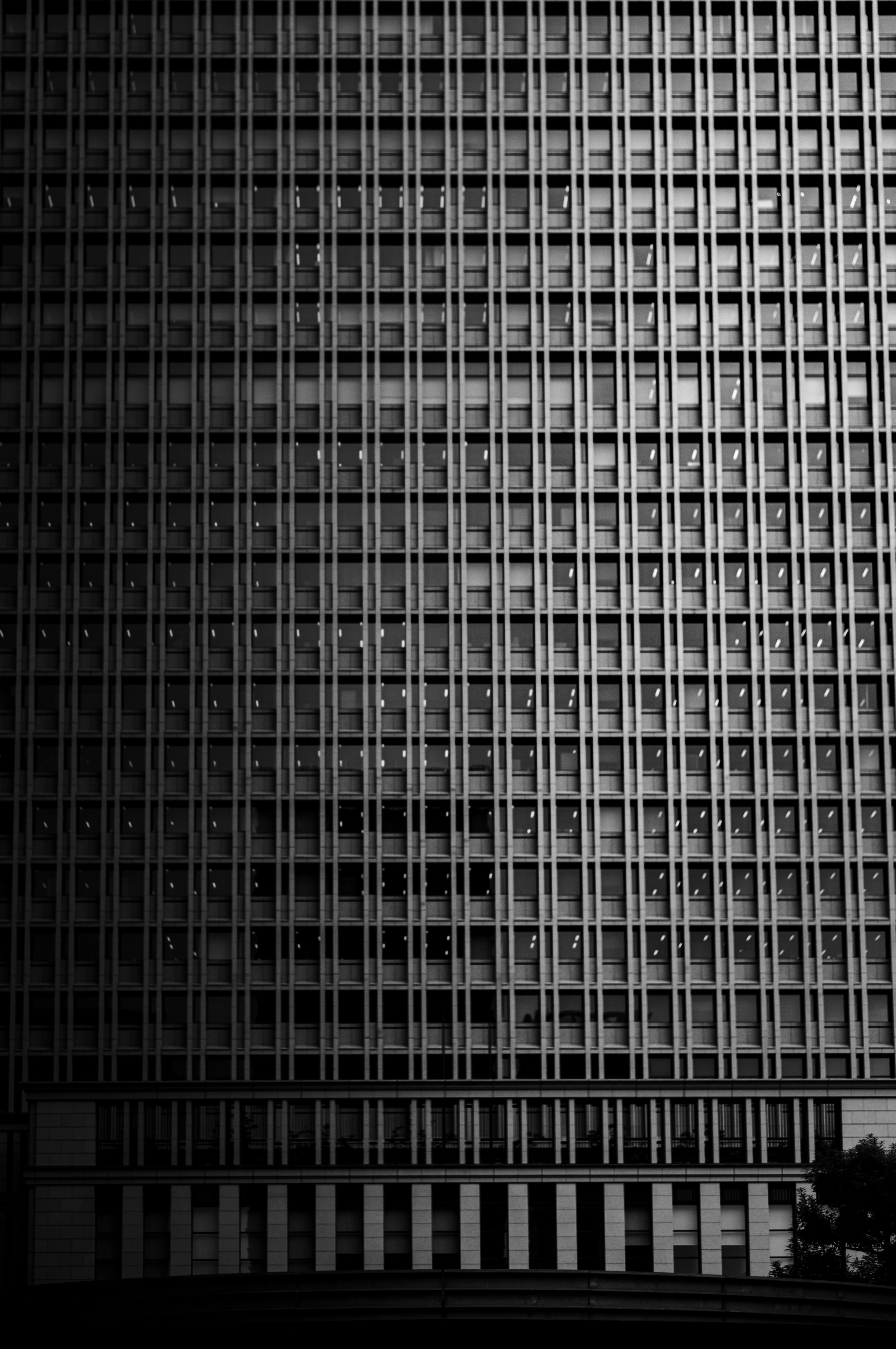 Fachada de edificio en blanco y negro con líneas verticales y ventanas