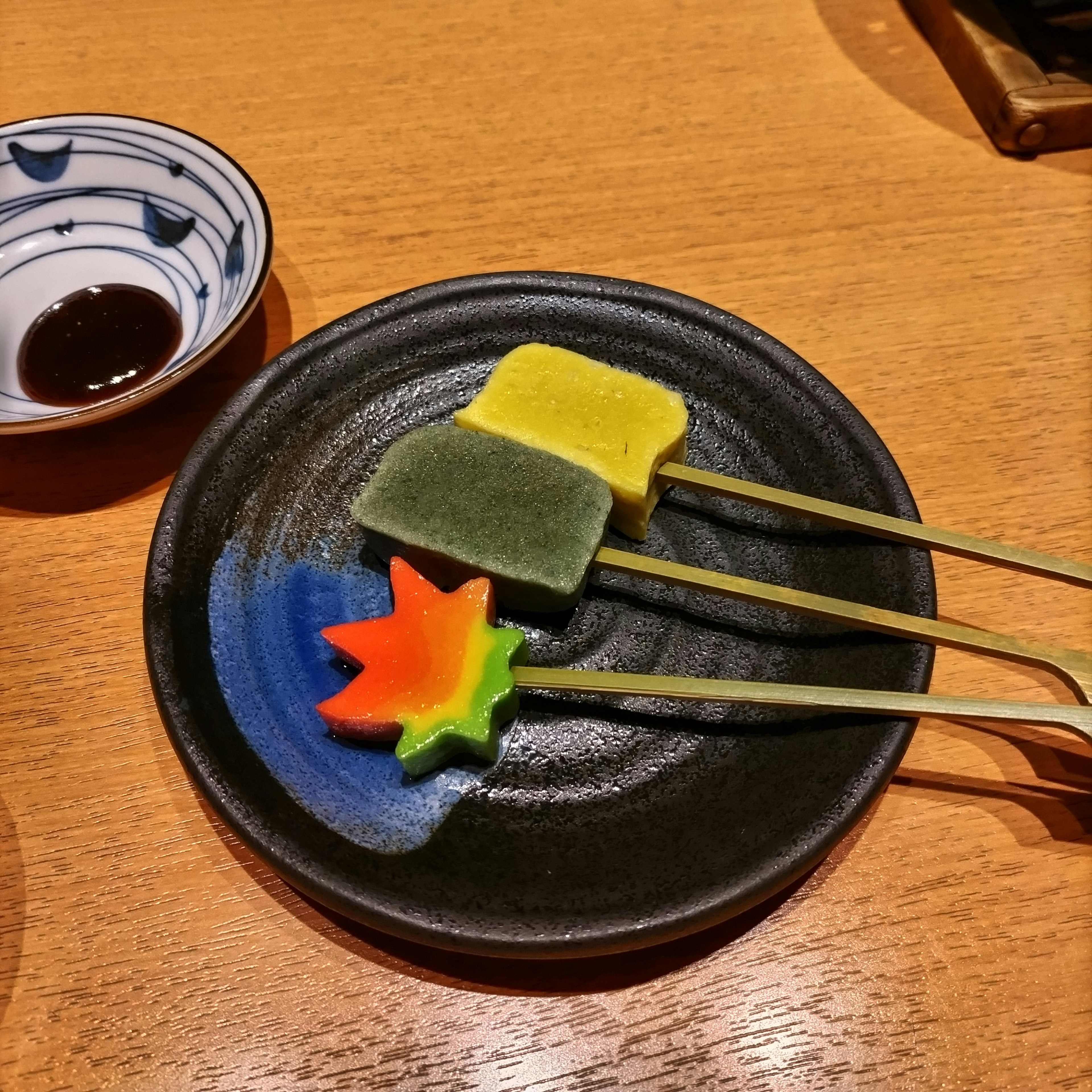 Colorful wagashi displayed on a black plate