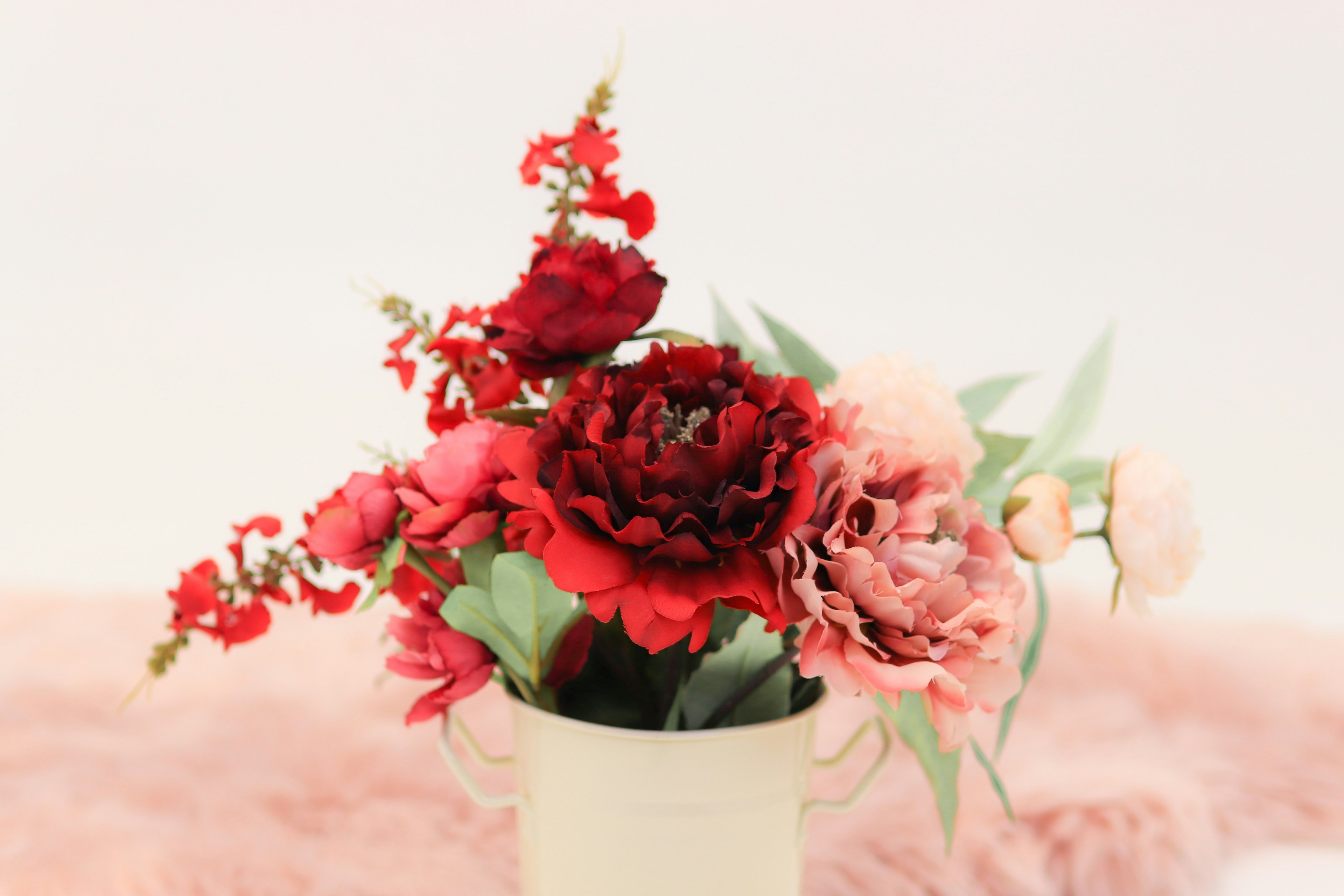 Bouquet of red and pink flowers in a white vase