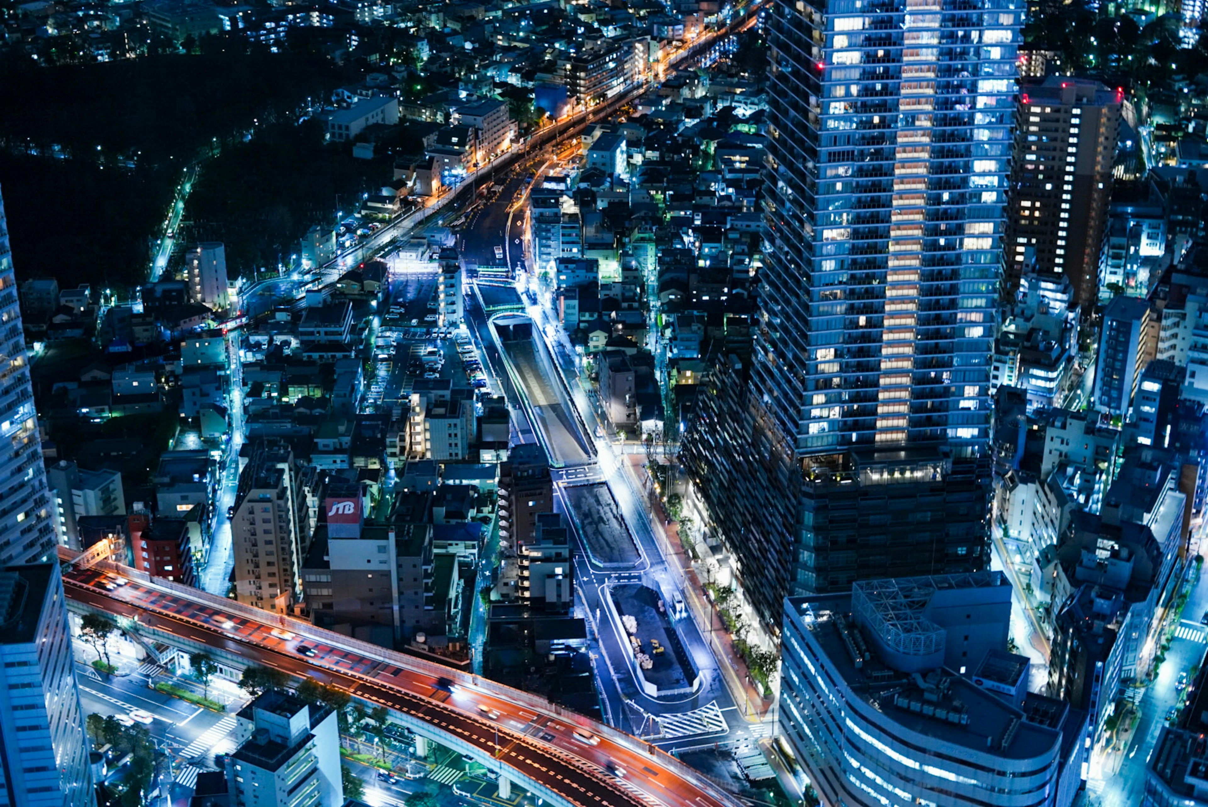 Night cityscape featuring illuminated skyscrapers and busy roads