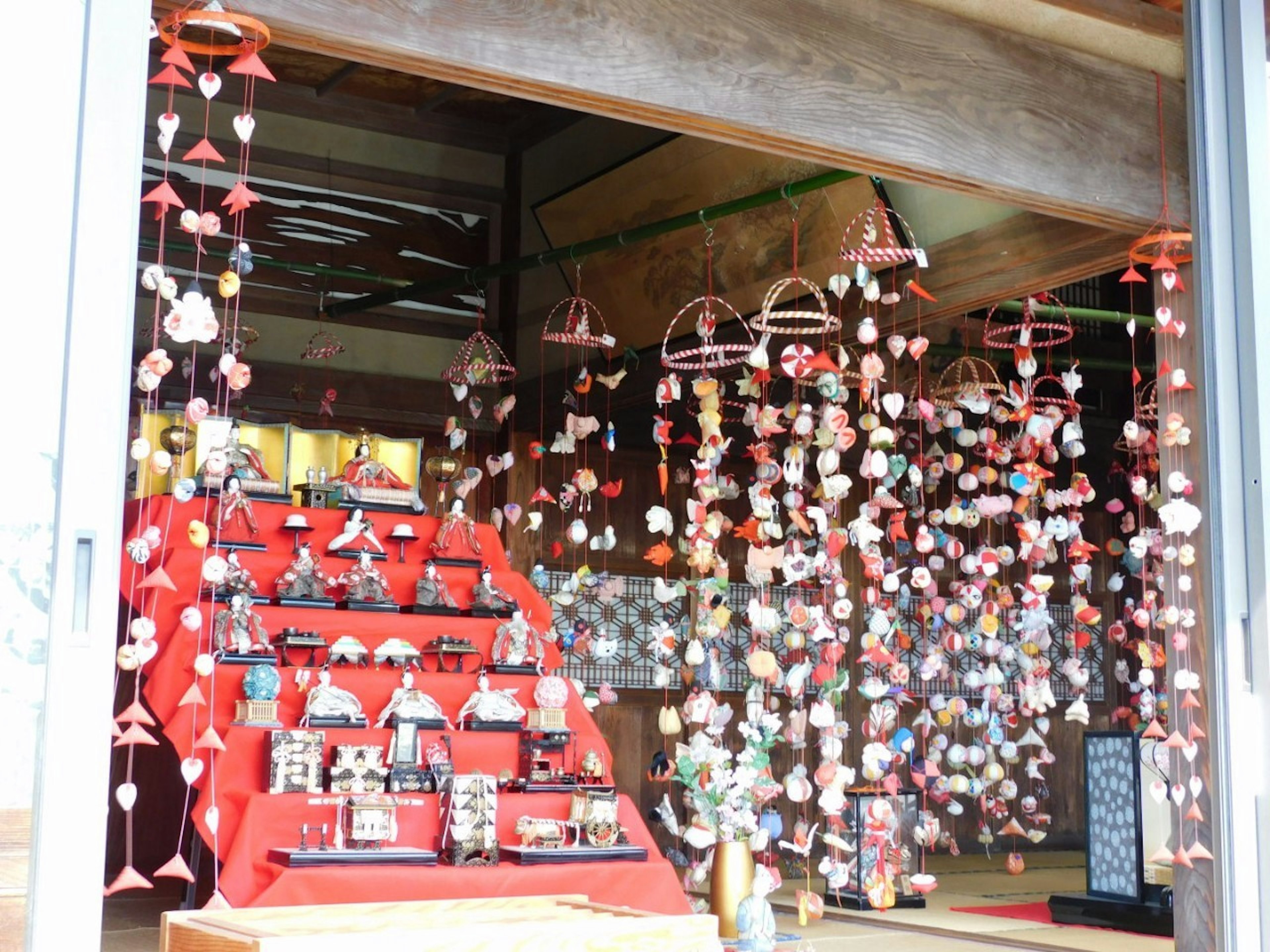 Interior toko Jepang tradisional dengan dekorasi merah dan boneka hina