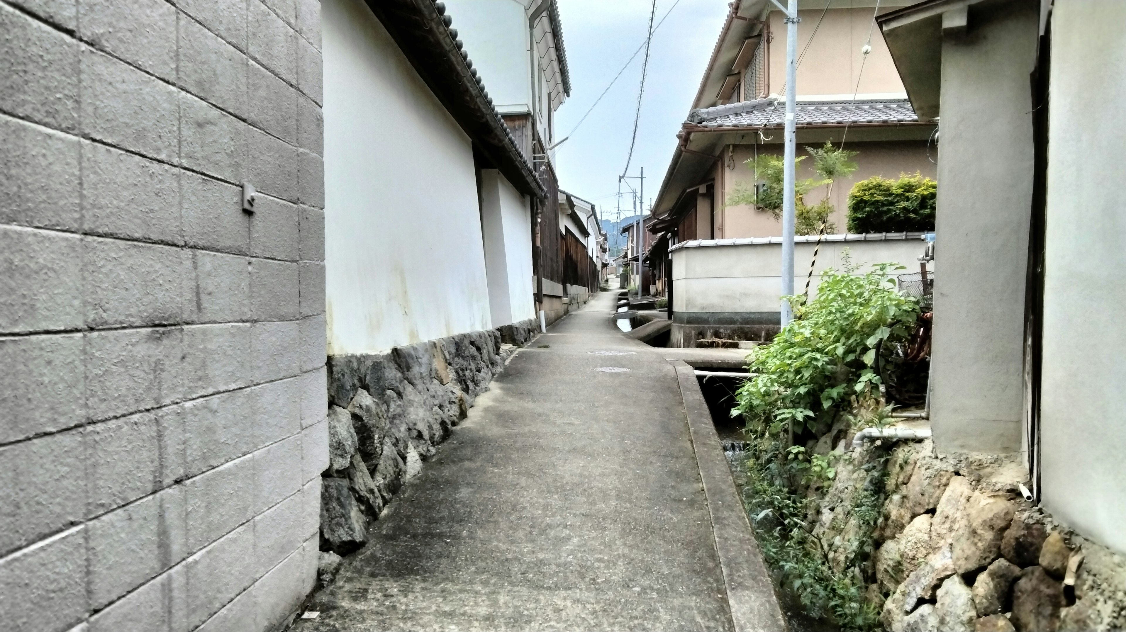 宁静的街道场景，狭窄的小路两旁是石墙和传统房屋