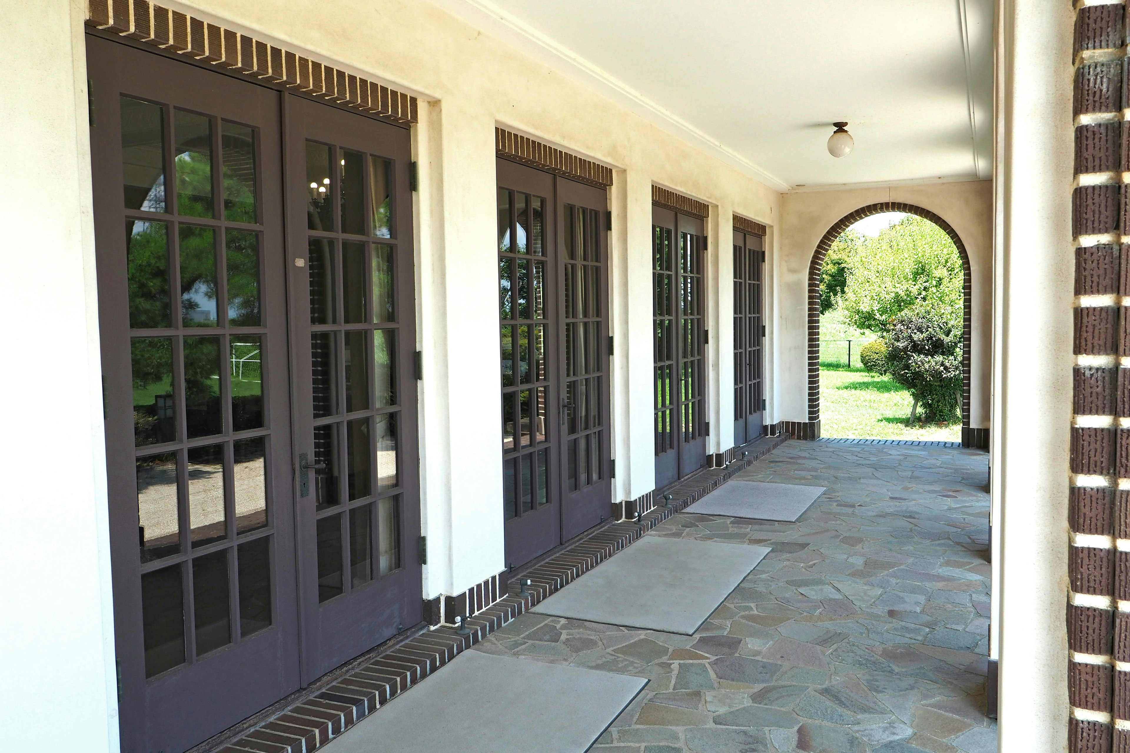 Arcada elegante con puertas de vidrio y suelo de piedra