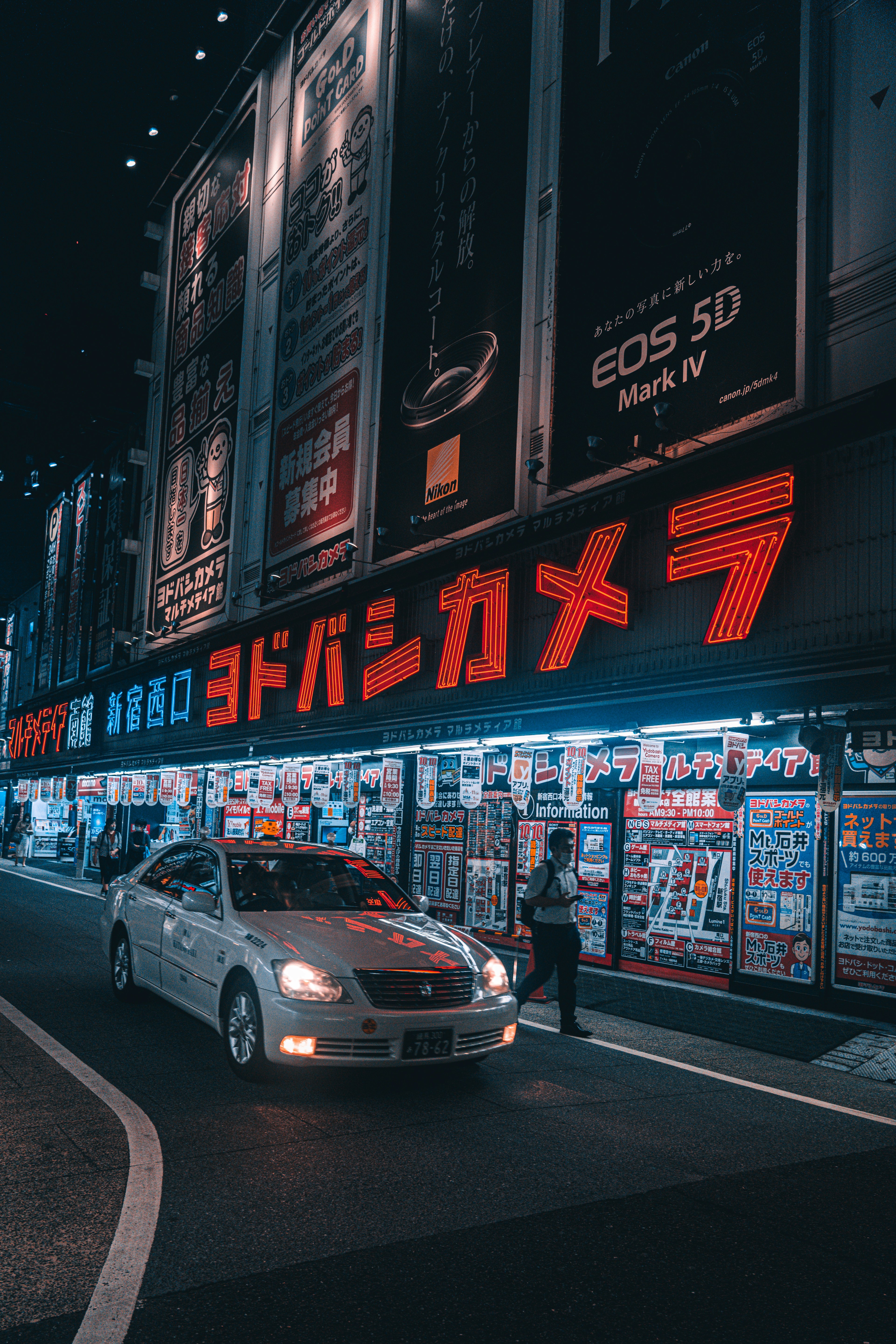 夜の都市風景にあるヨドバシカメラの看板とタクシー