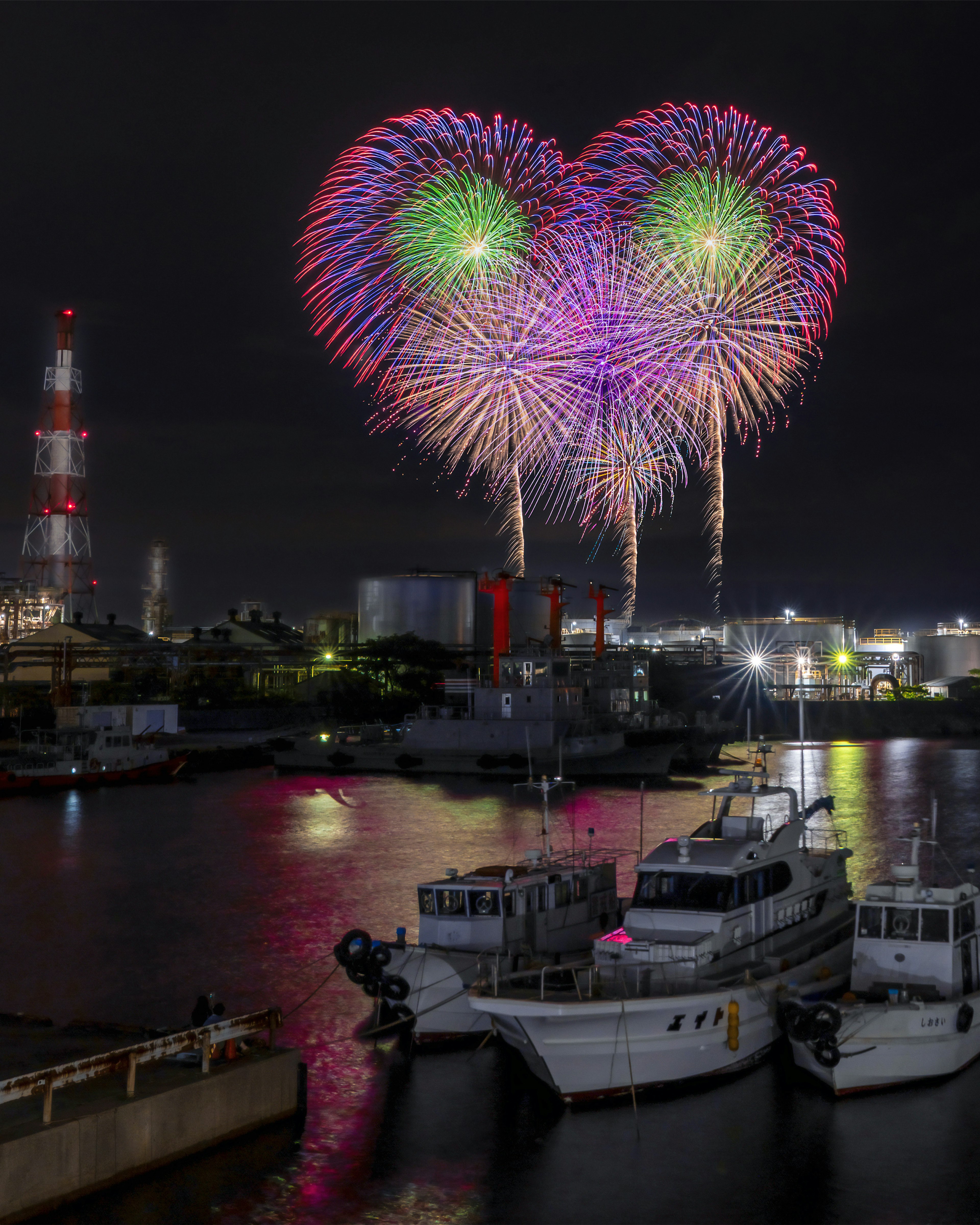 夜空に心形の花火が輝く港の風景と船