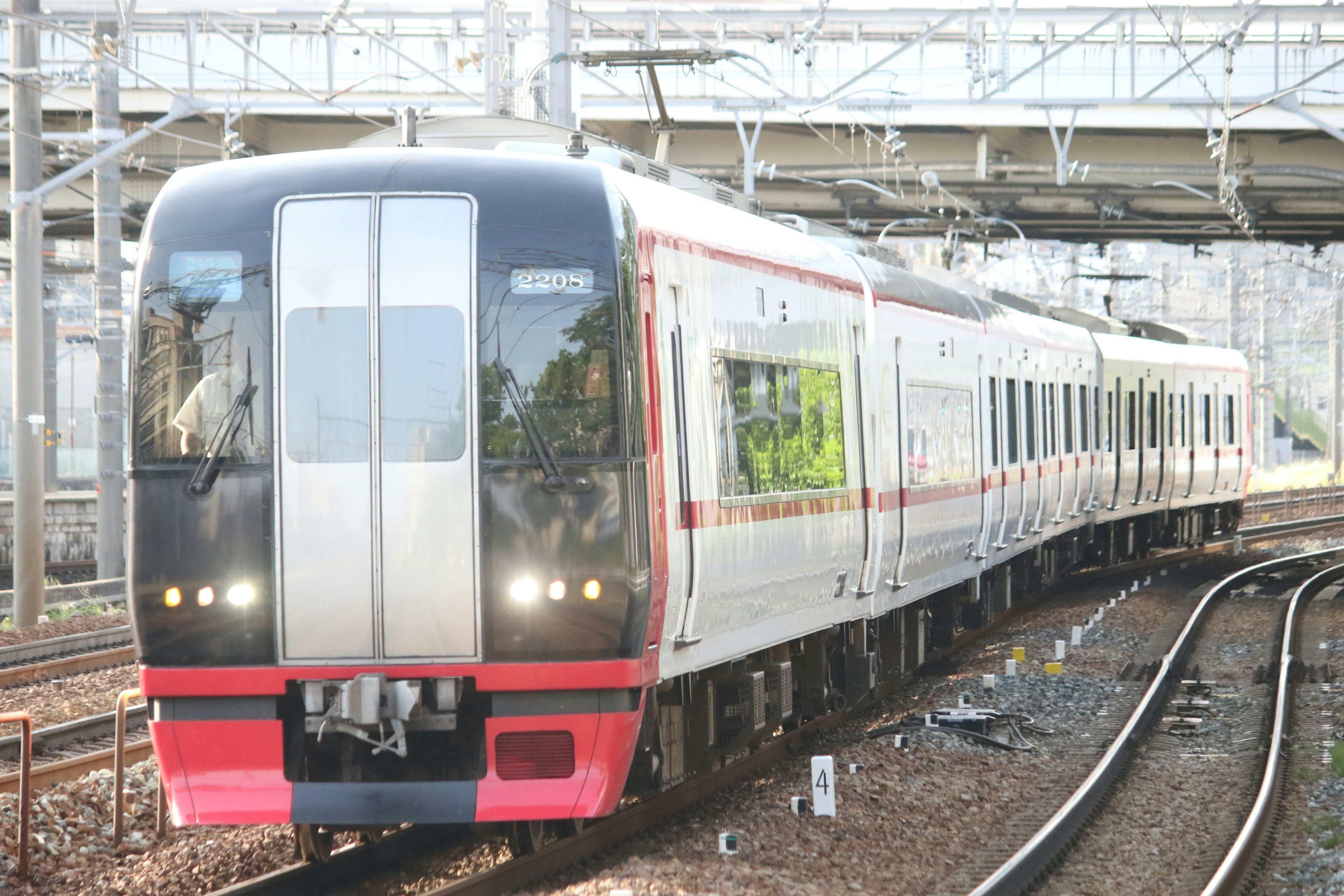 รถไฟที่มีการออกแบบสีแดงและขาววิ่งอยู่บนราง