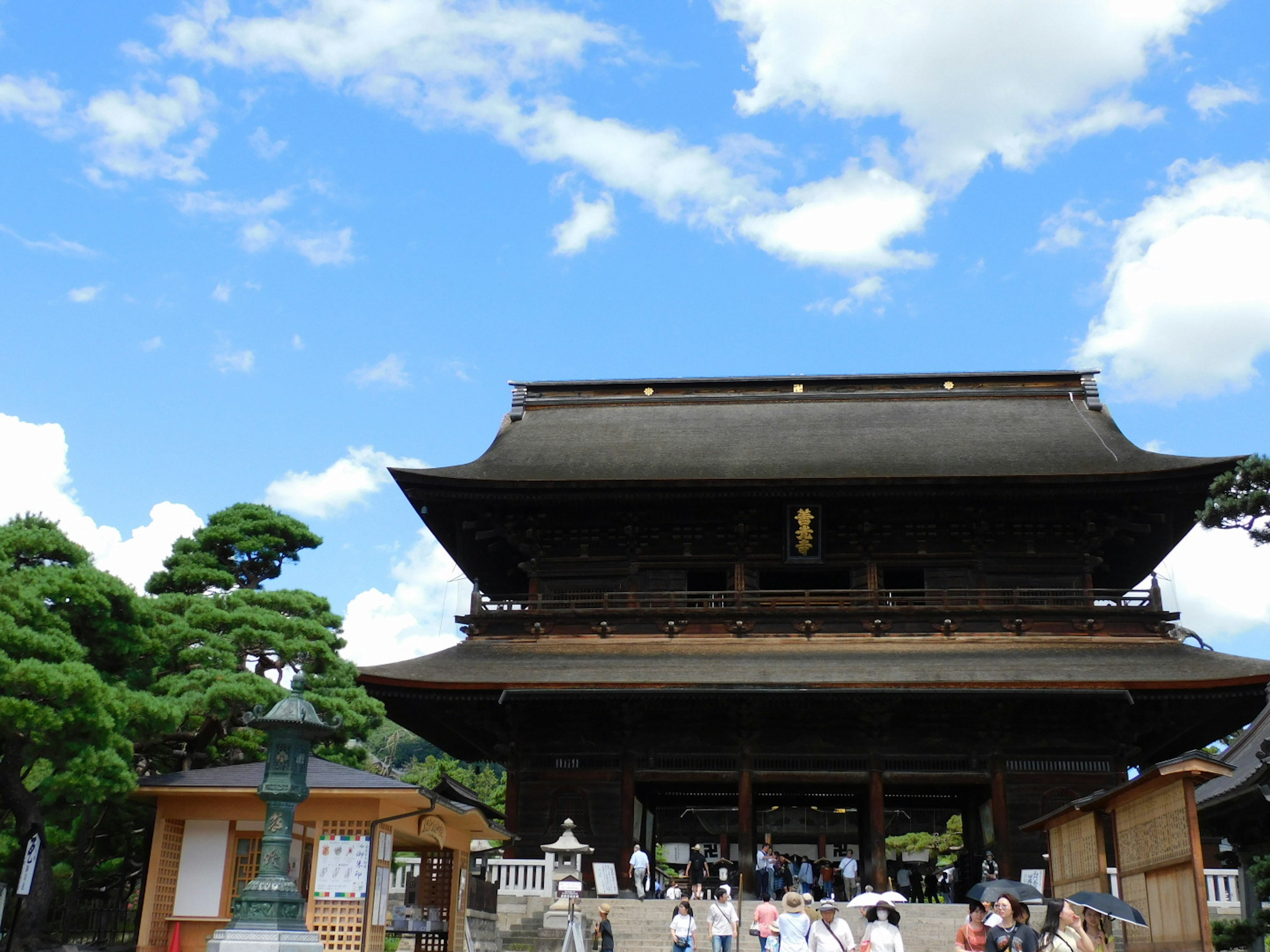 Traditional Japanese temple gate with visitors under blue sky