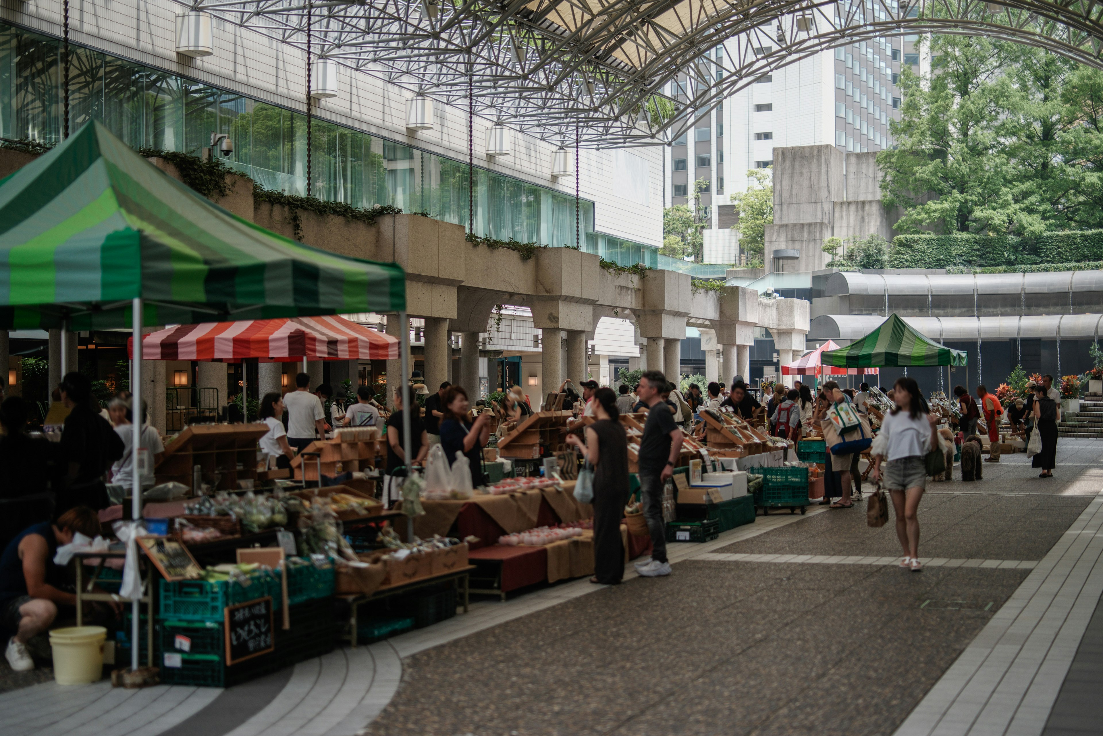 Busy market scene with colorful stalls and people under a canopy