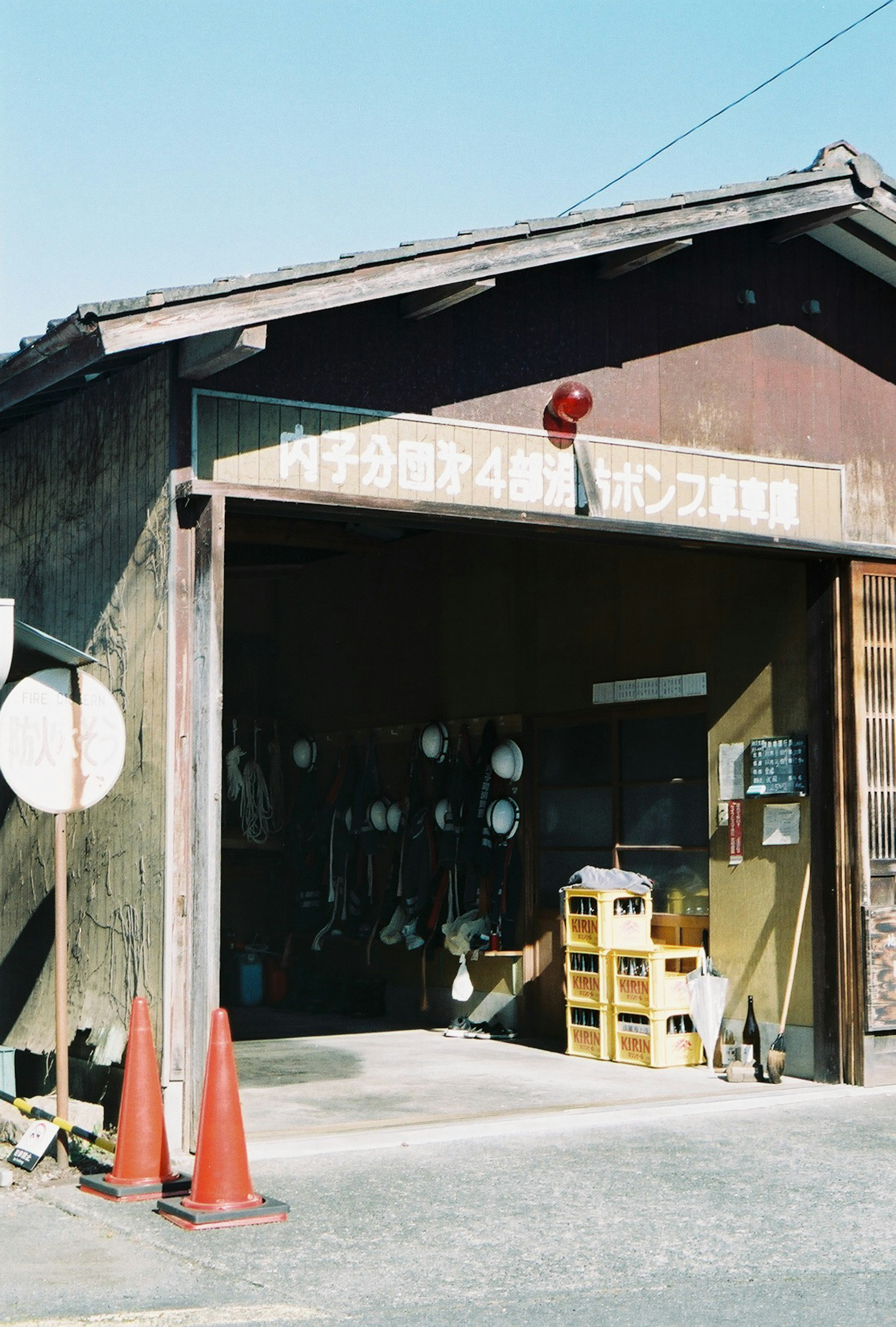 Esterno di un vecchio magazzino con luce di avvertimento rossa e coni arancioni