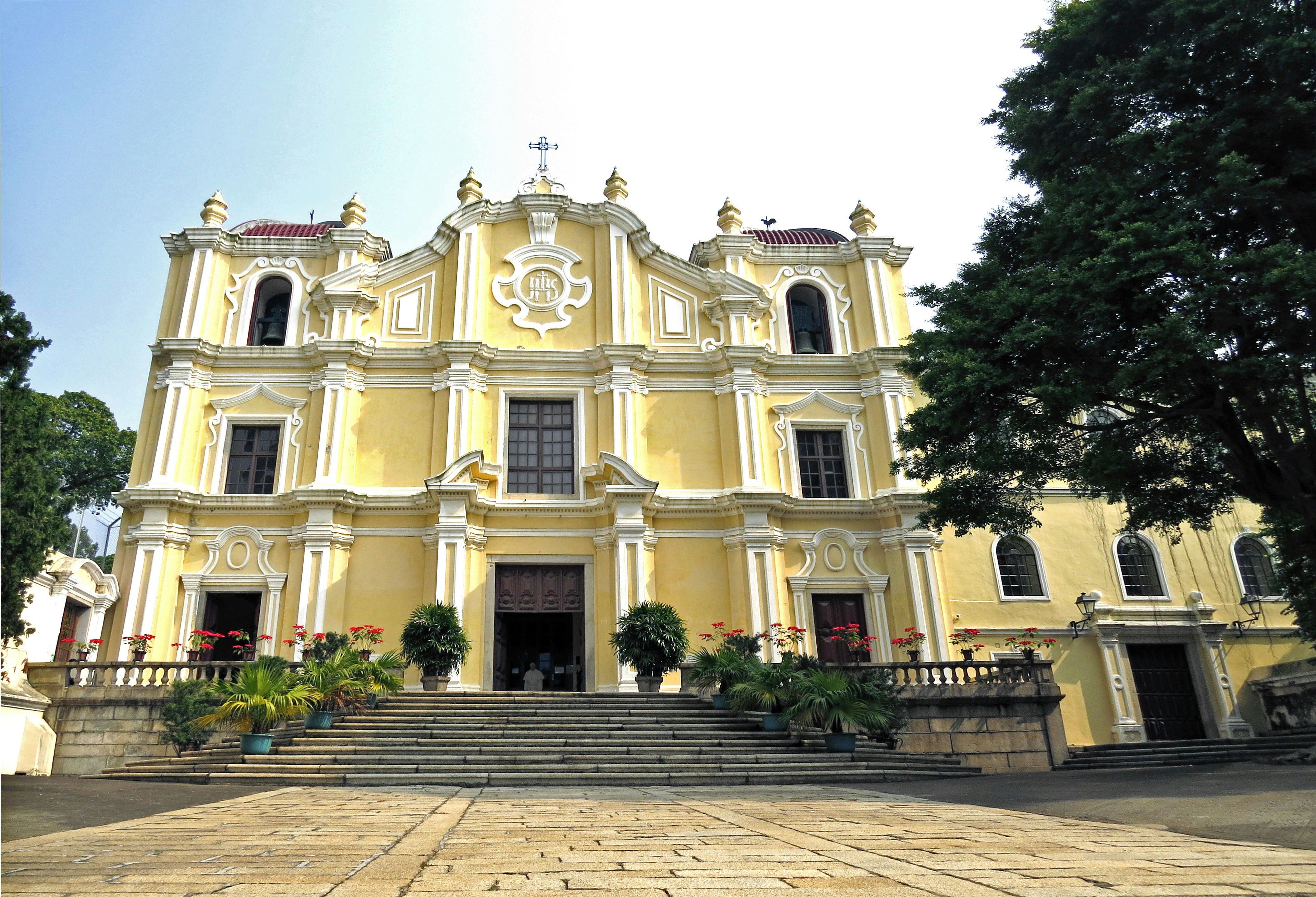 Facciata gialla di una chiesa gesuita con scale eleganti