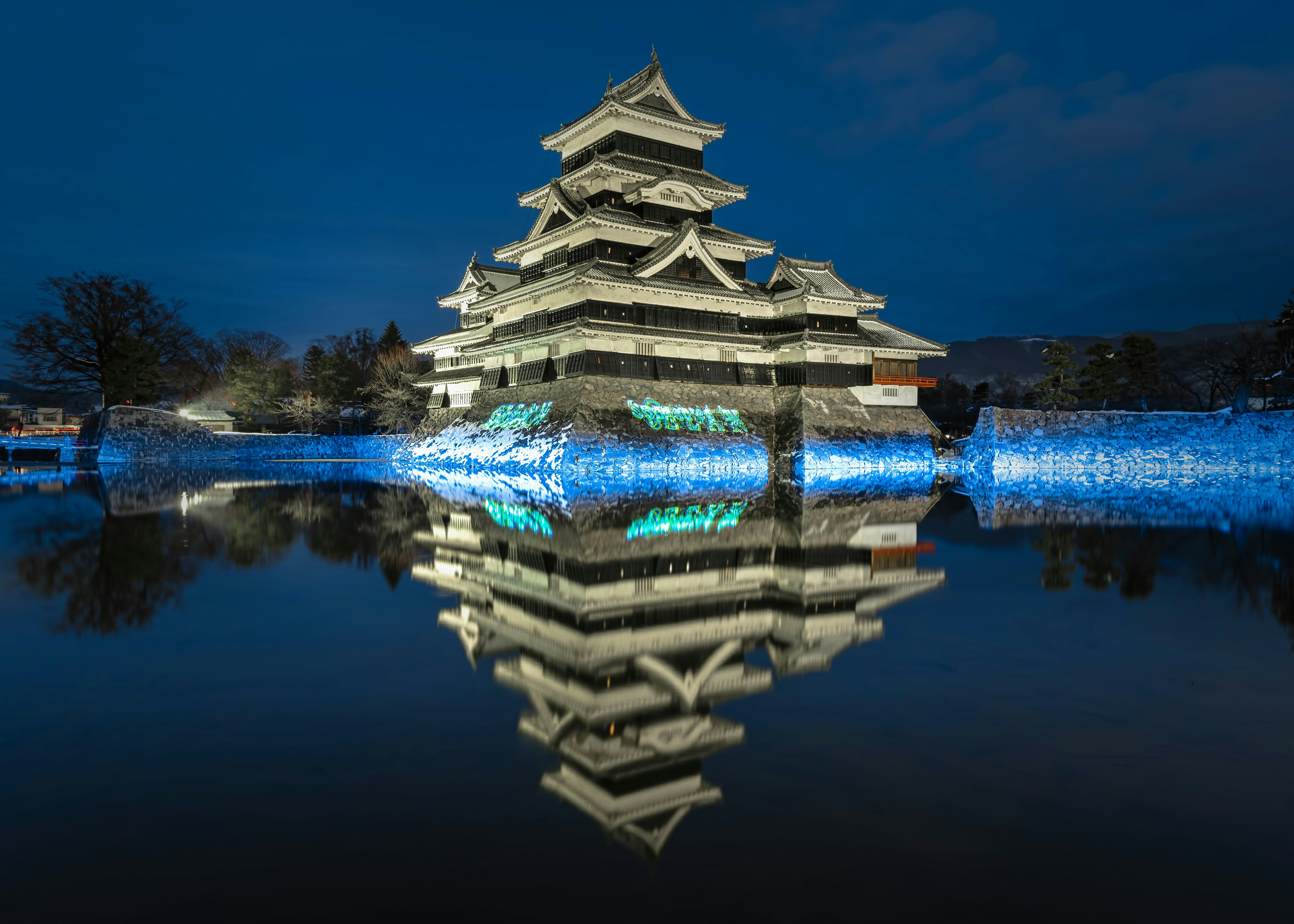 Castello di Matsumoto di notte con riflesso sull'acqua