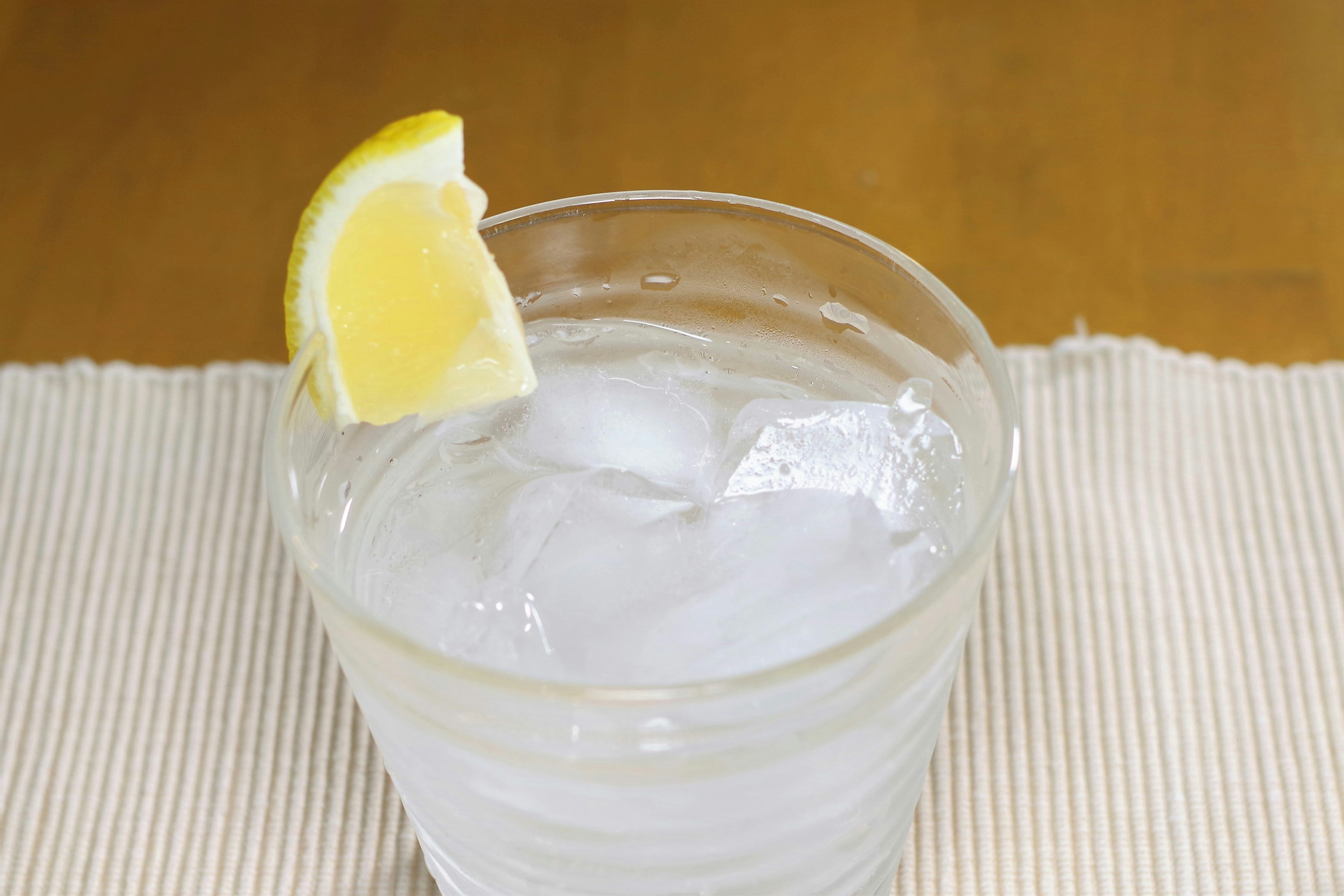 Glass of clear drink with ice and a slice of lemon