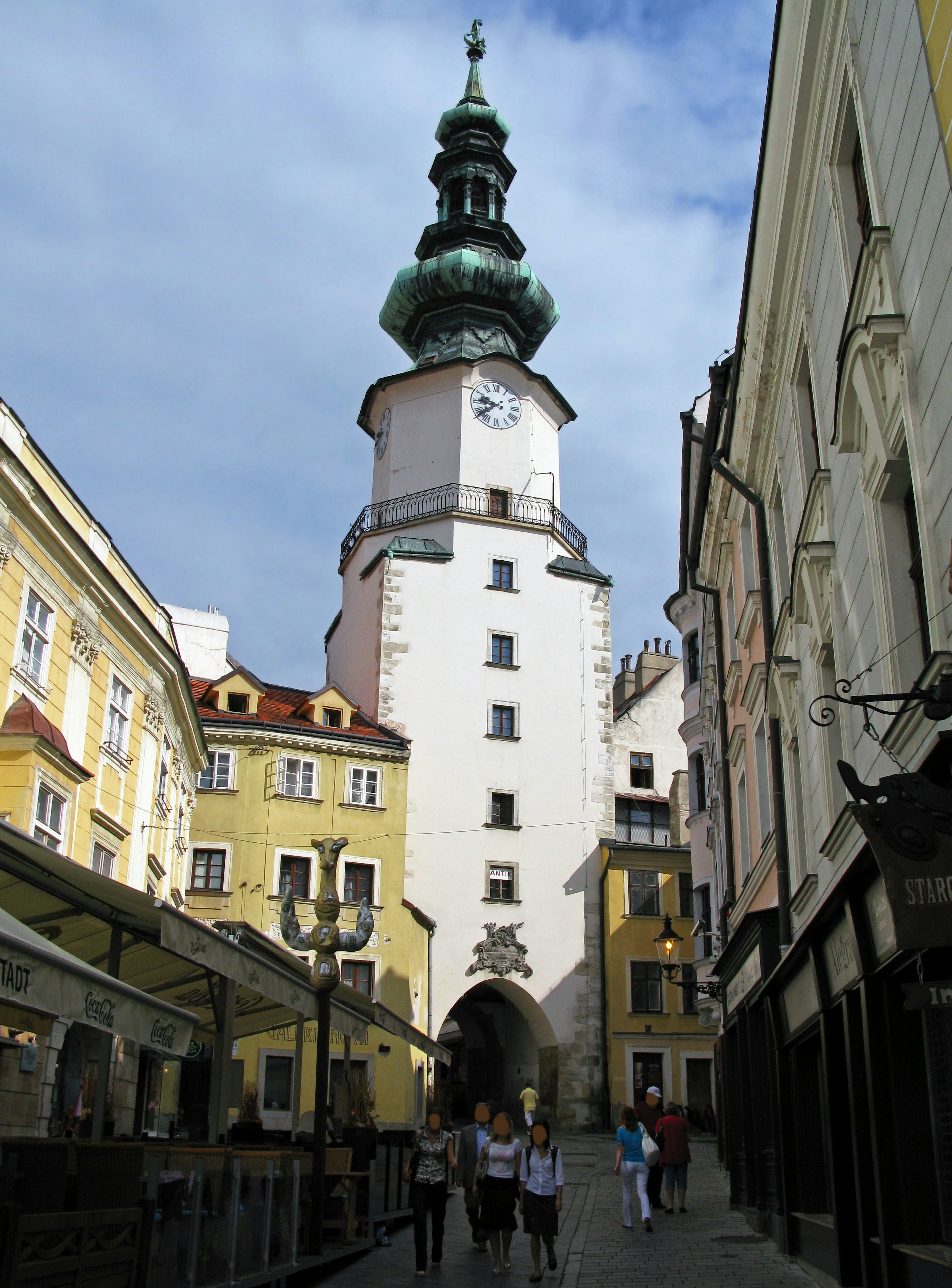 Historische Straße mit einem weißen Turm und einem grünen Kuppeldach