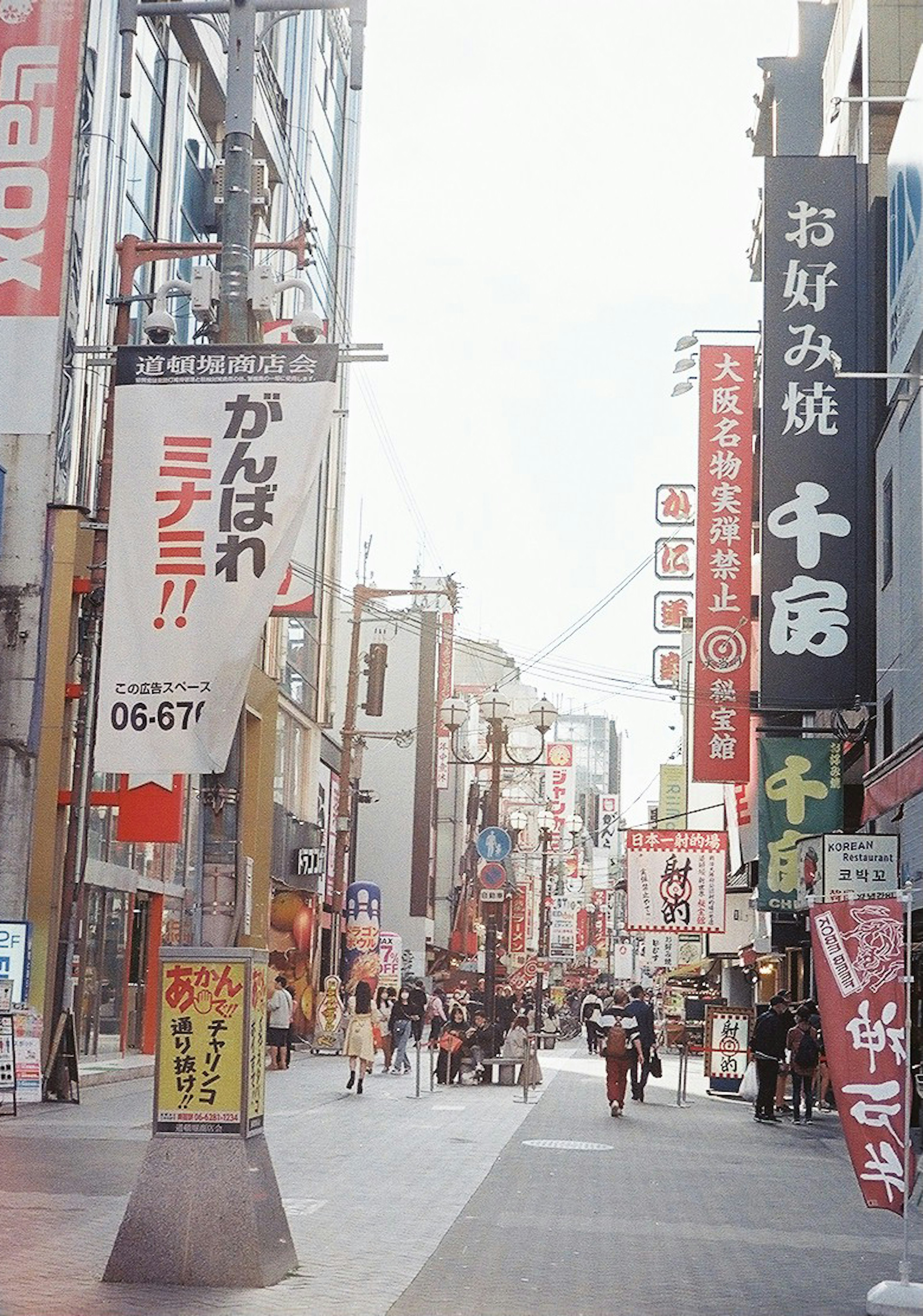 Rue animée avec divers panneaux de restaurants et magasins