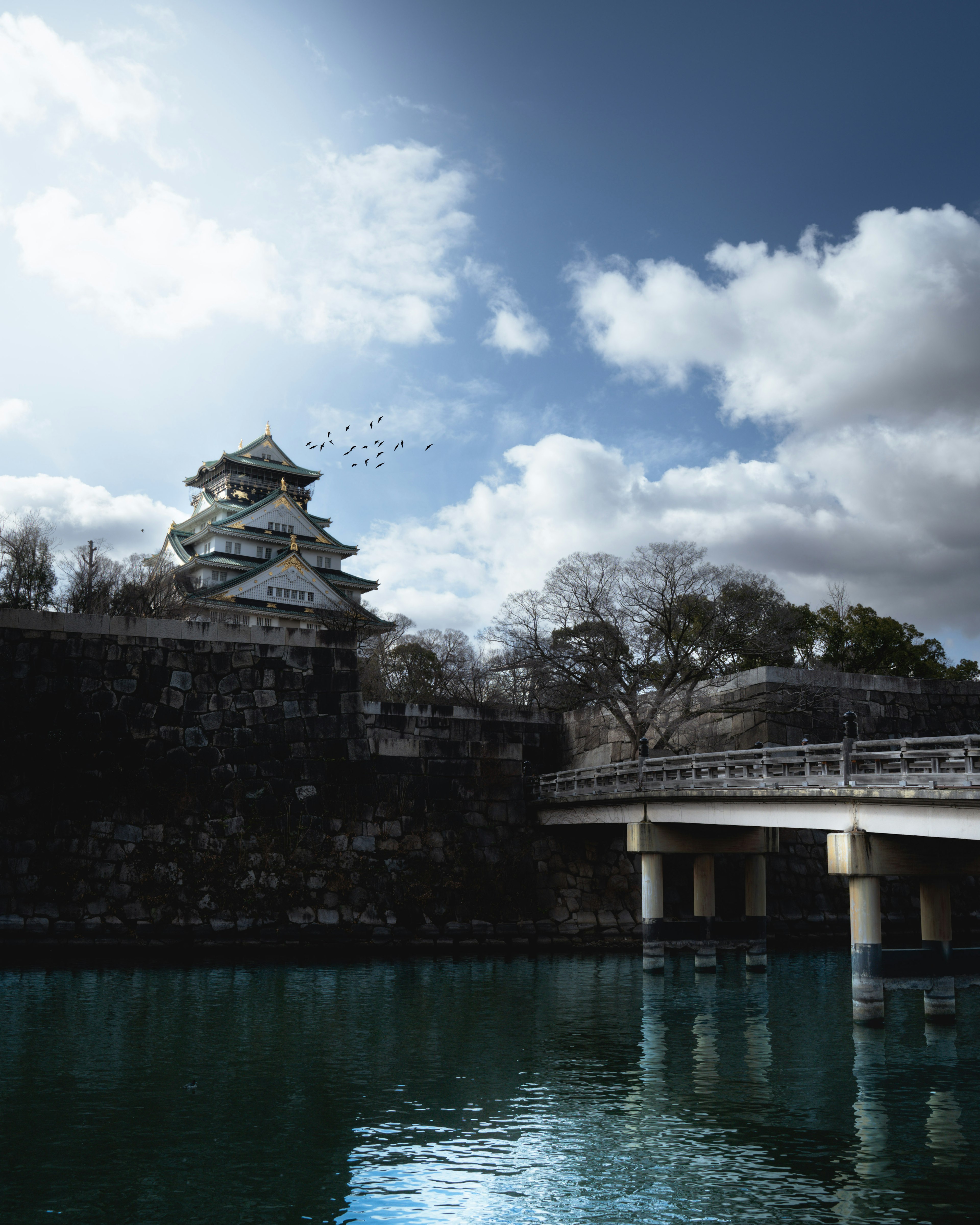 Un bellissimo castello si erge sull'acqua con un ponte e un cielo blu suggestivo