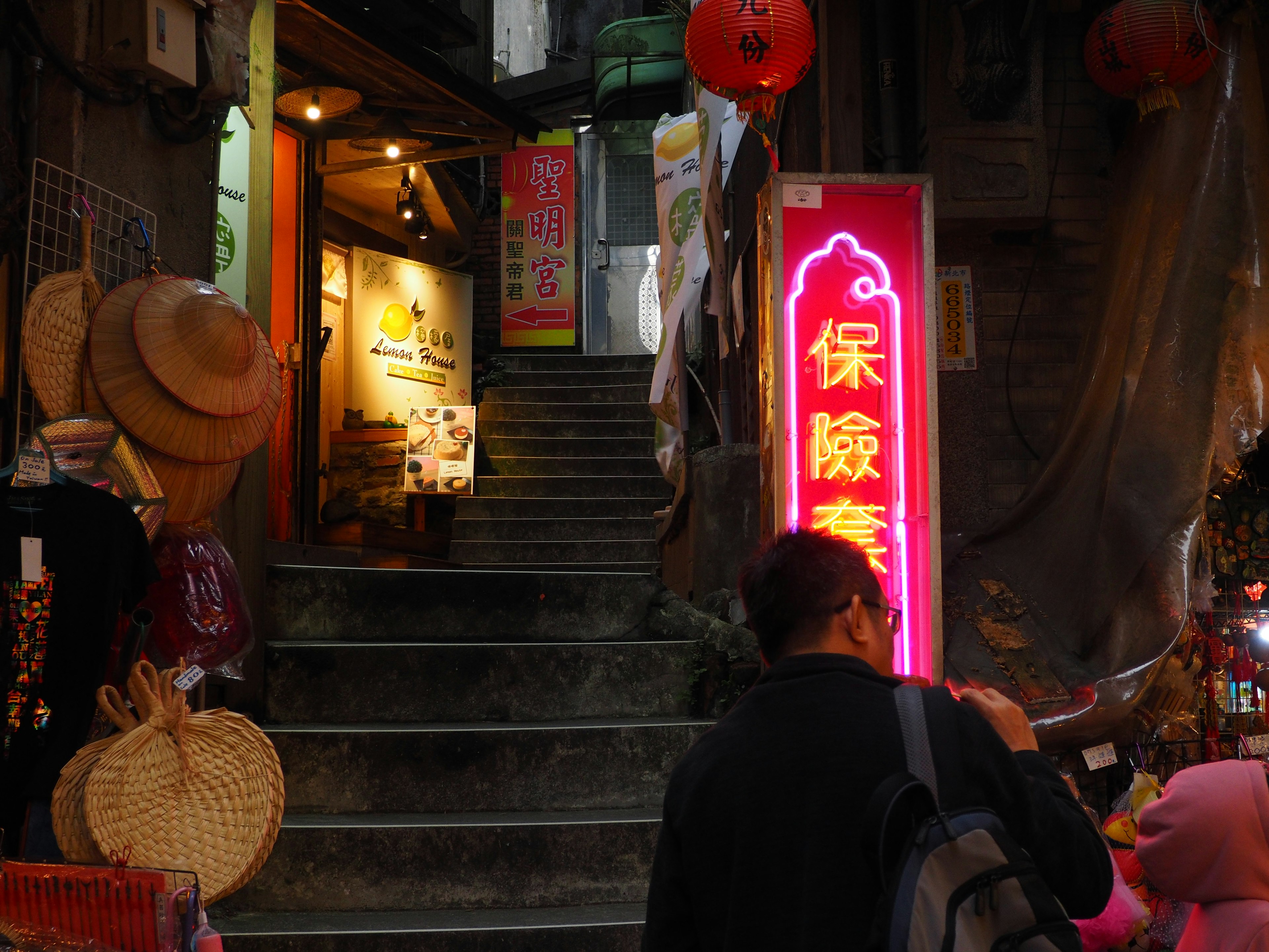 階段を上る人と赤い提灯のある商店街の風景