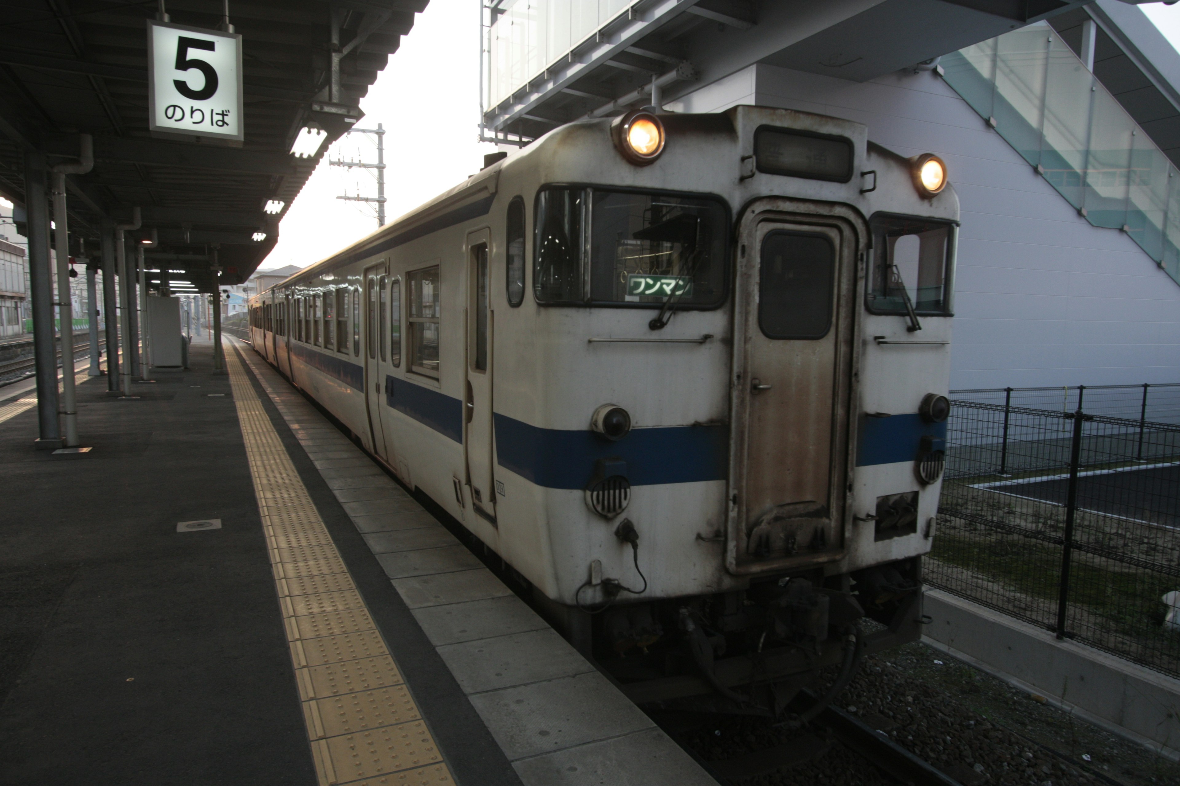 Vecchio treno blu e bianco fermo su una banchina della stazione