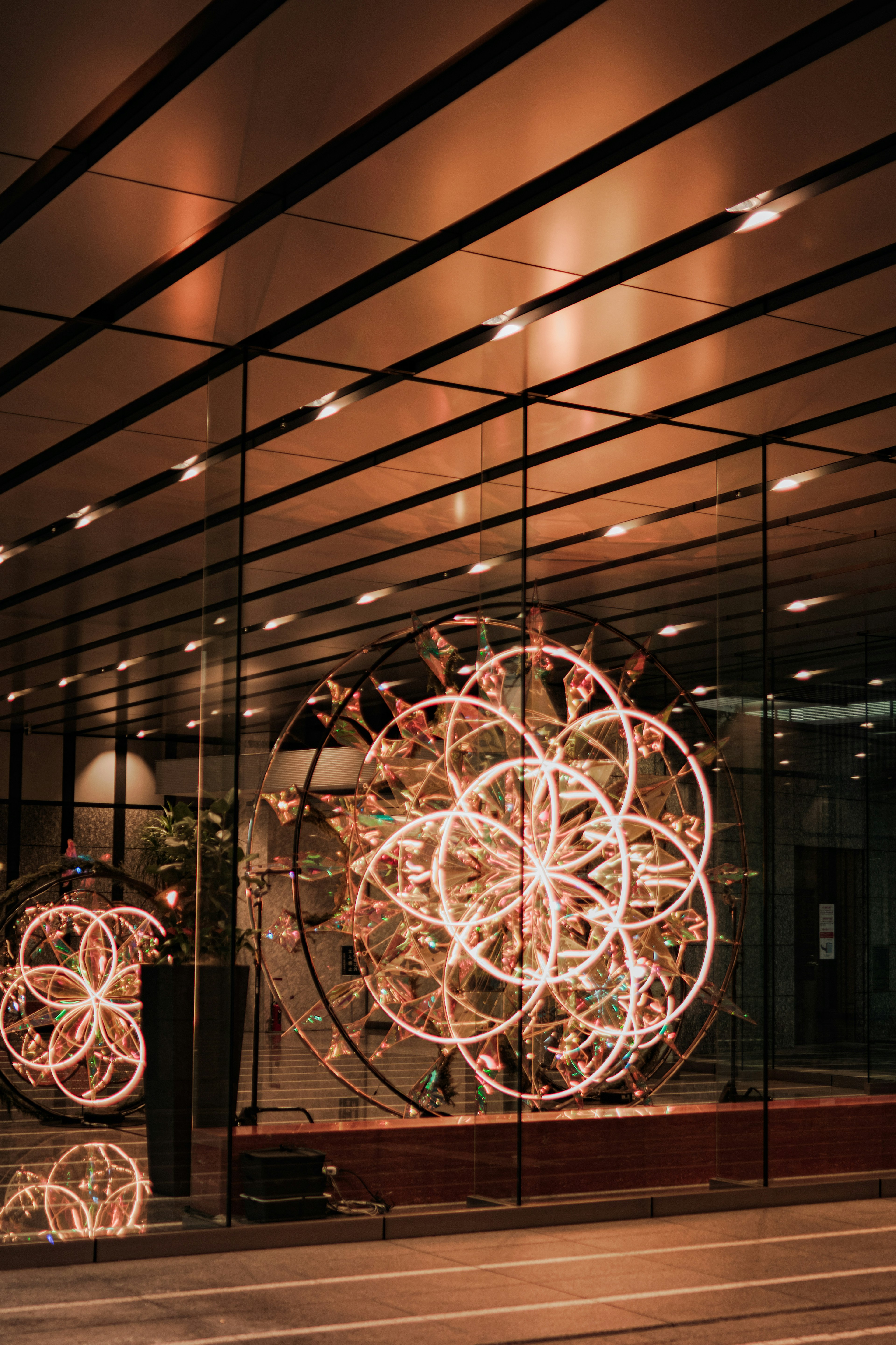 Elegant lighting installation visible through a glass wall with reflections