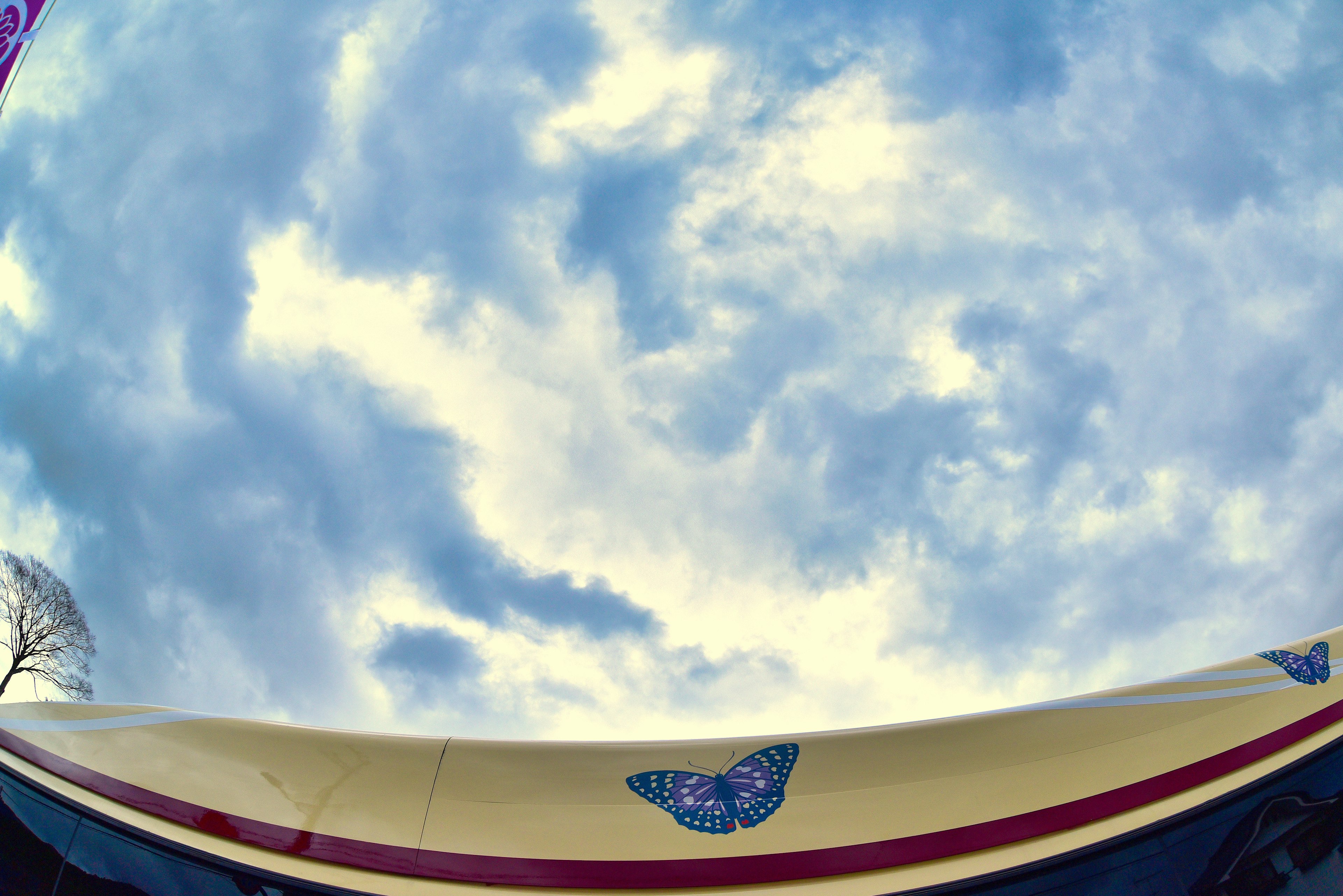 A photo showing a blue sky with clouds and part of a boat below