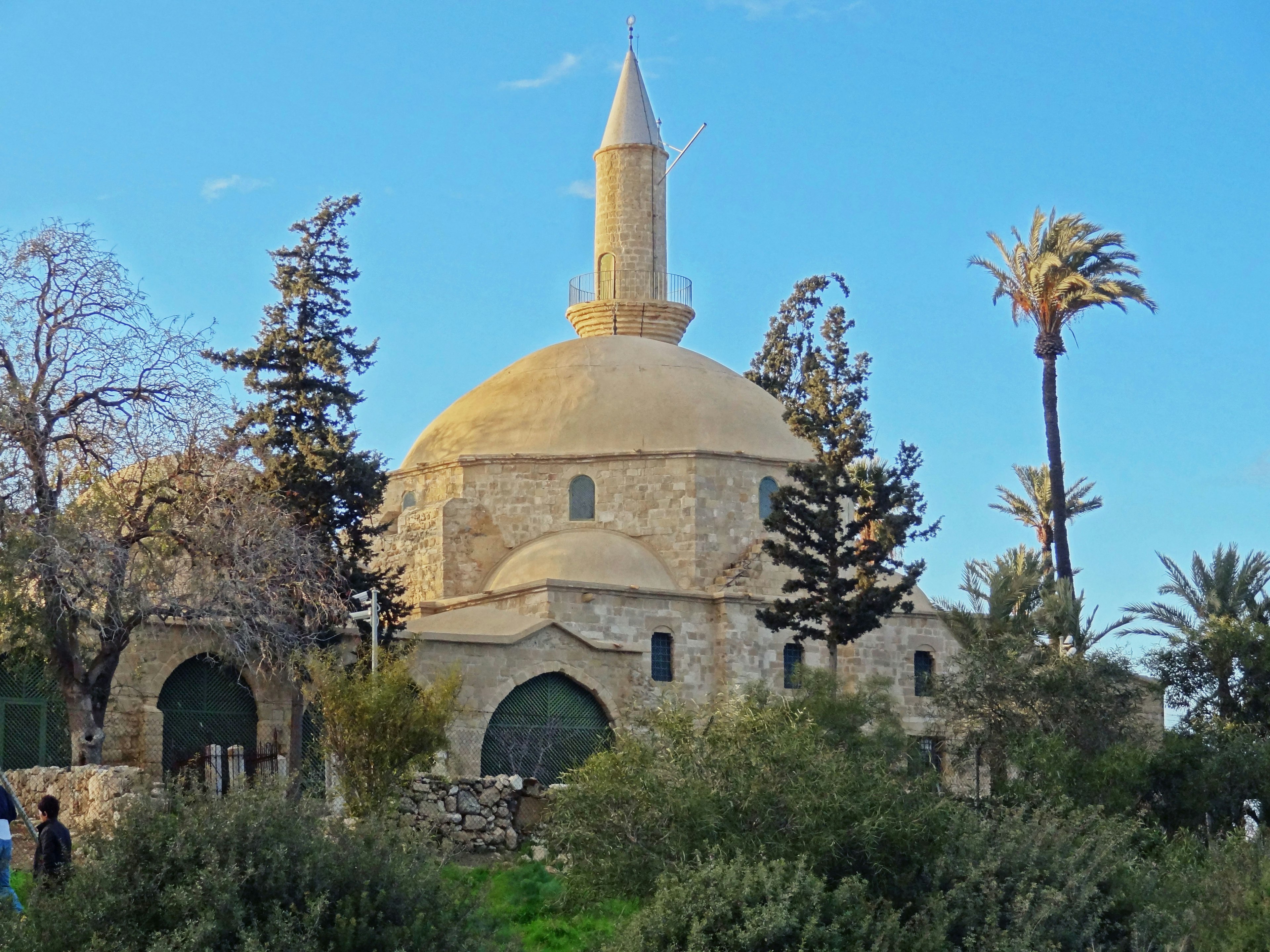 Old stone mosque with surrounding trees and blue sky