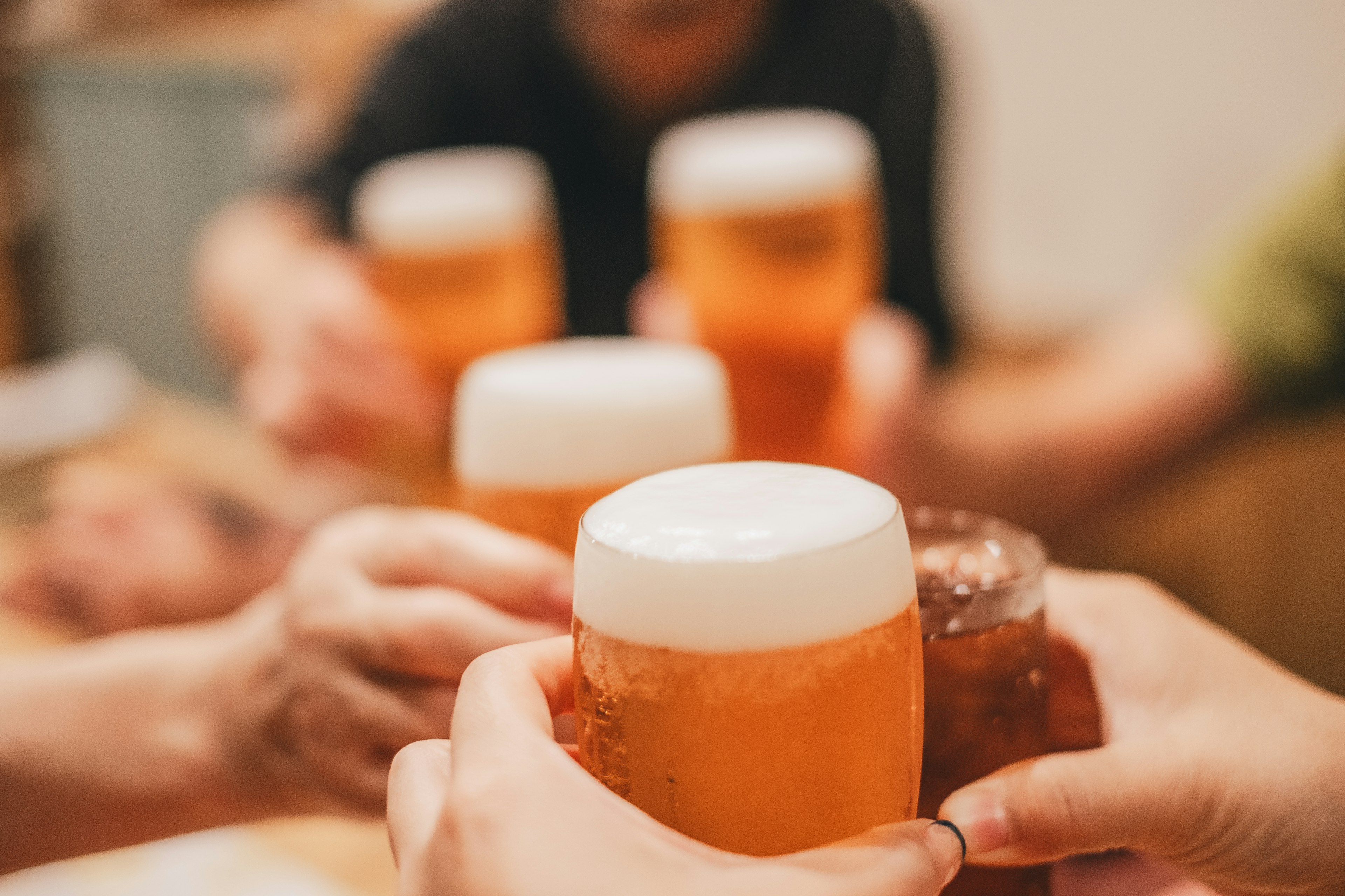 Mains tenant des verres de bière lors d'un toast