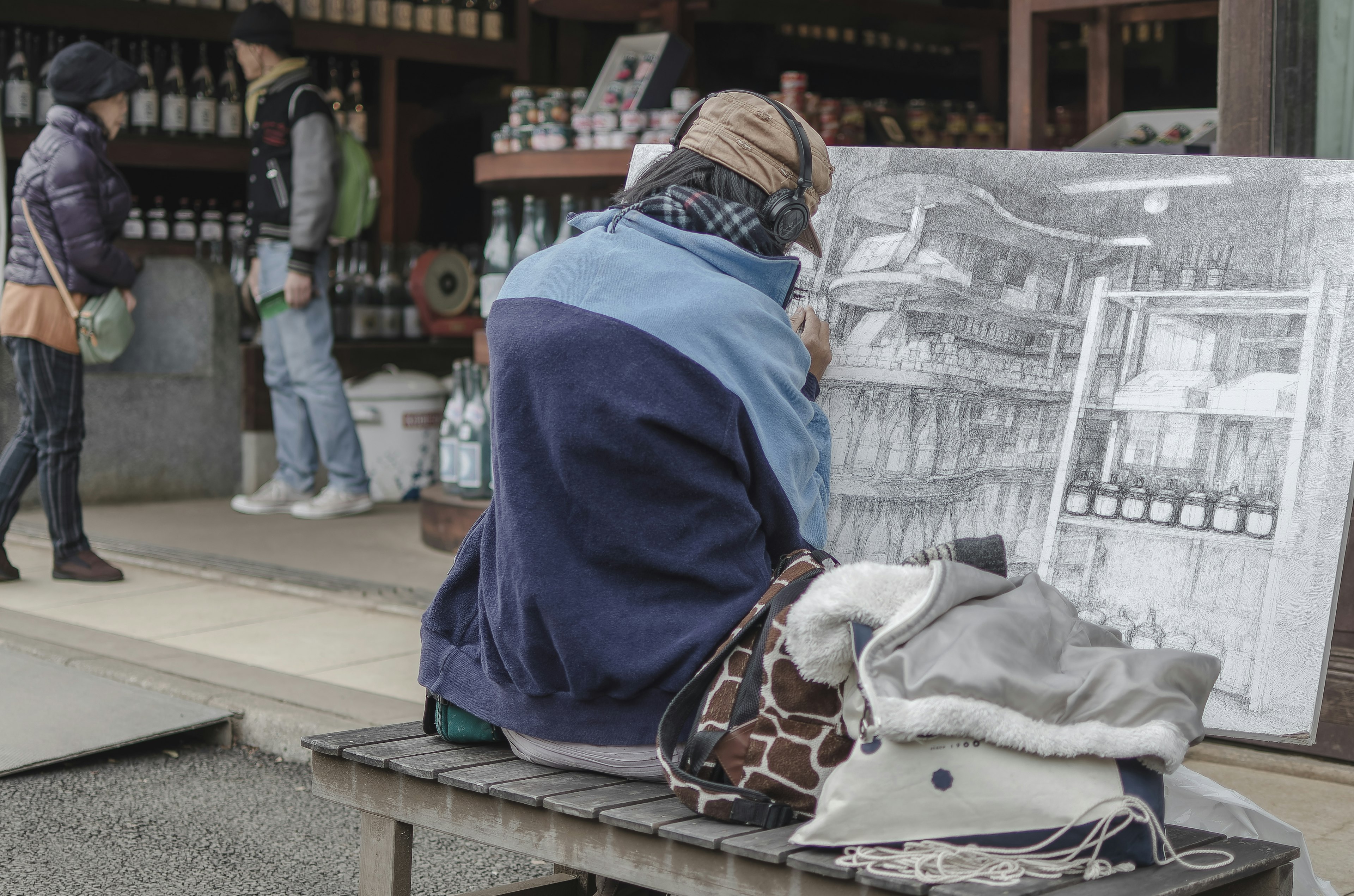 추운 날씨에 그림을 그리고 있는 사람과 주변 사람들