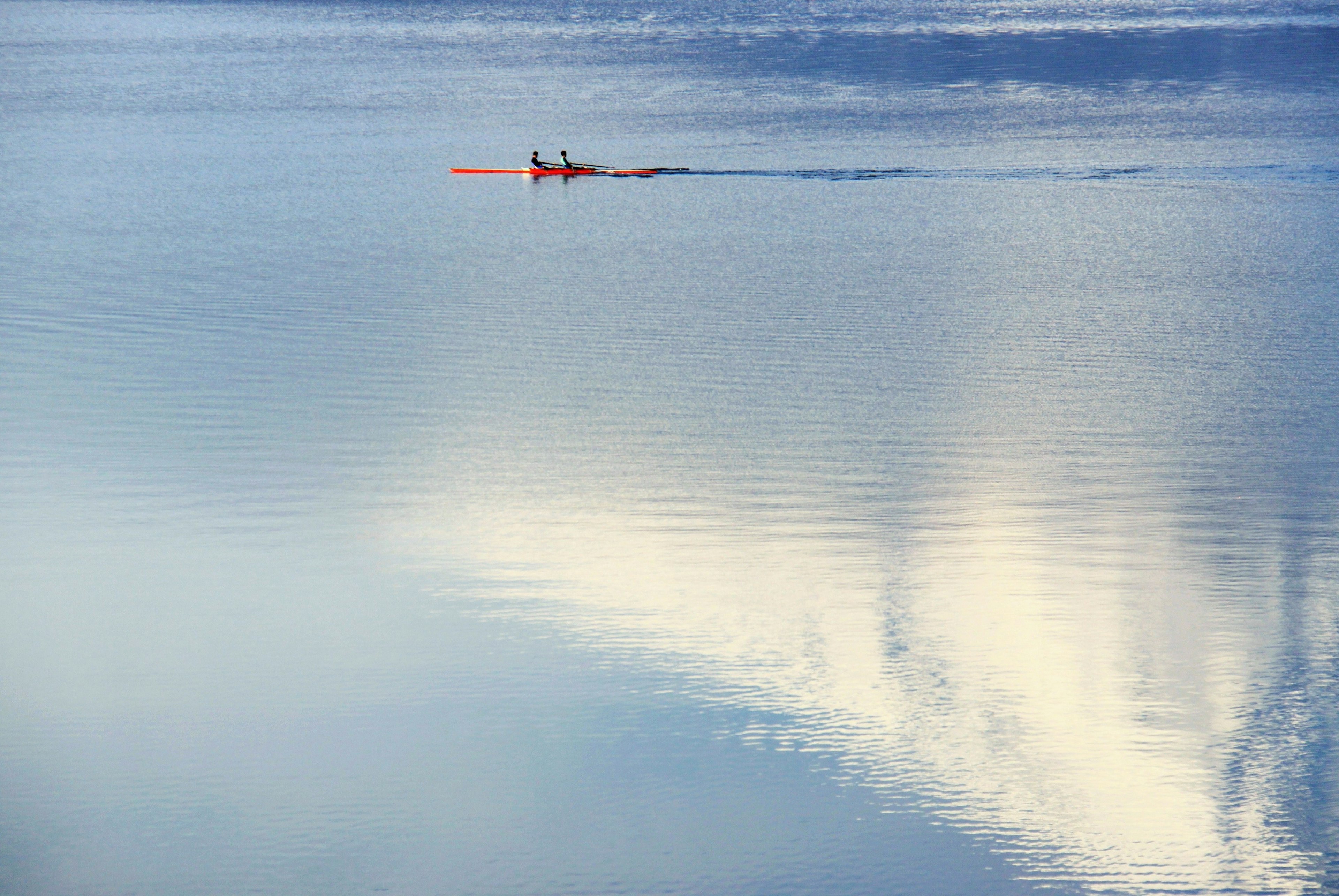 Una persona in kayak su un lago calmo con riflessi