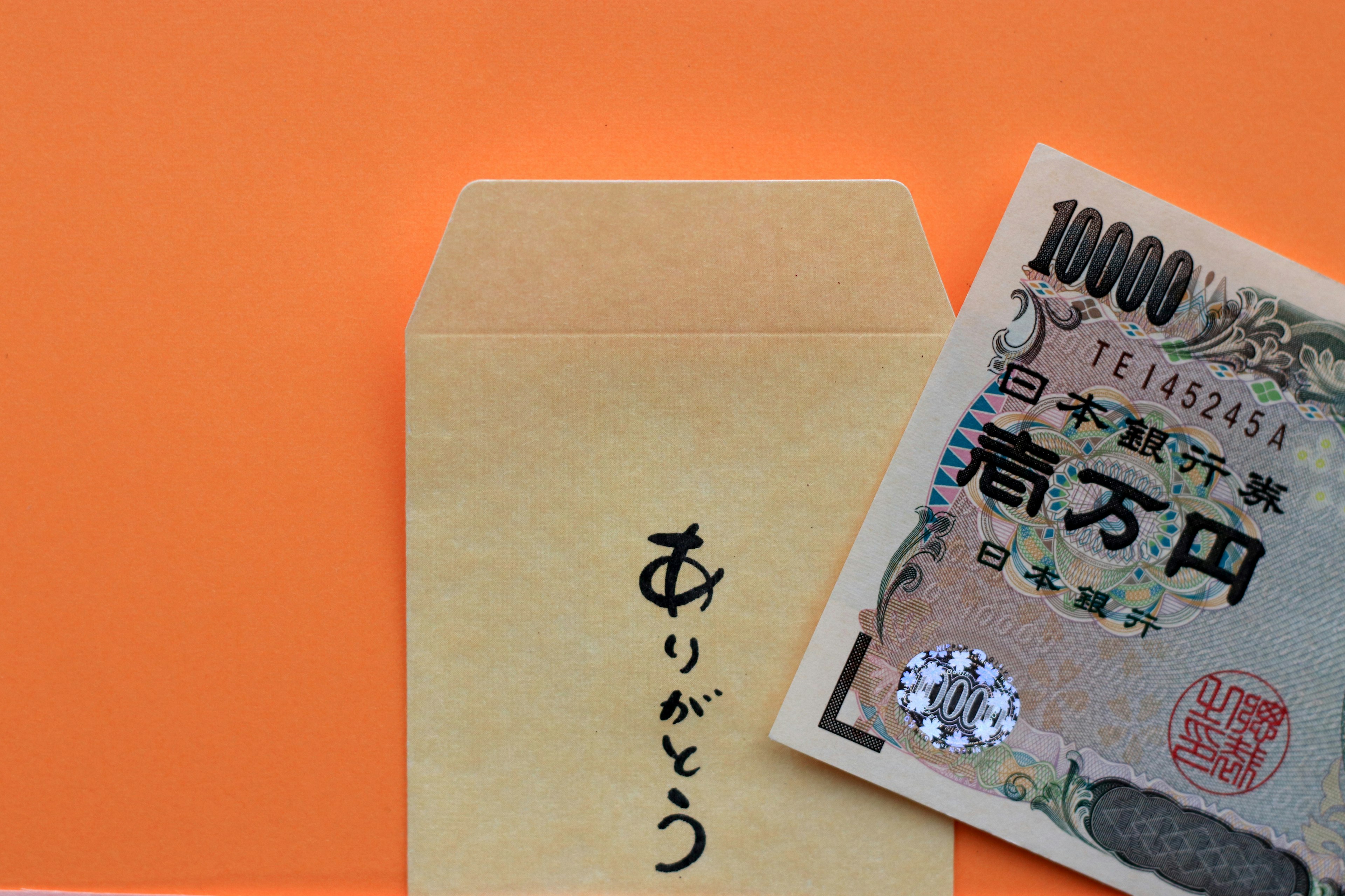 A gold envelope with Japanese yen on an orange background