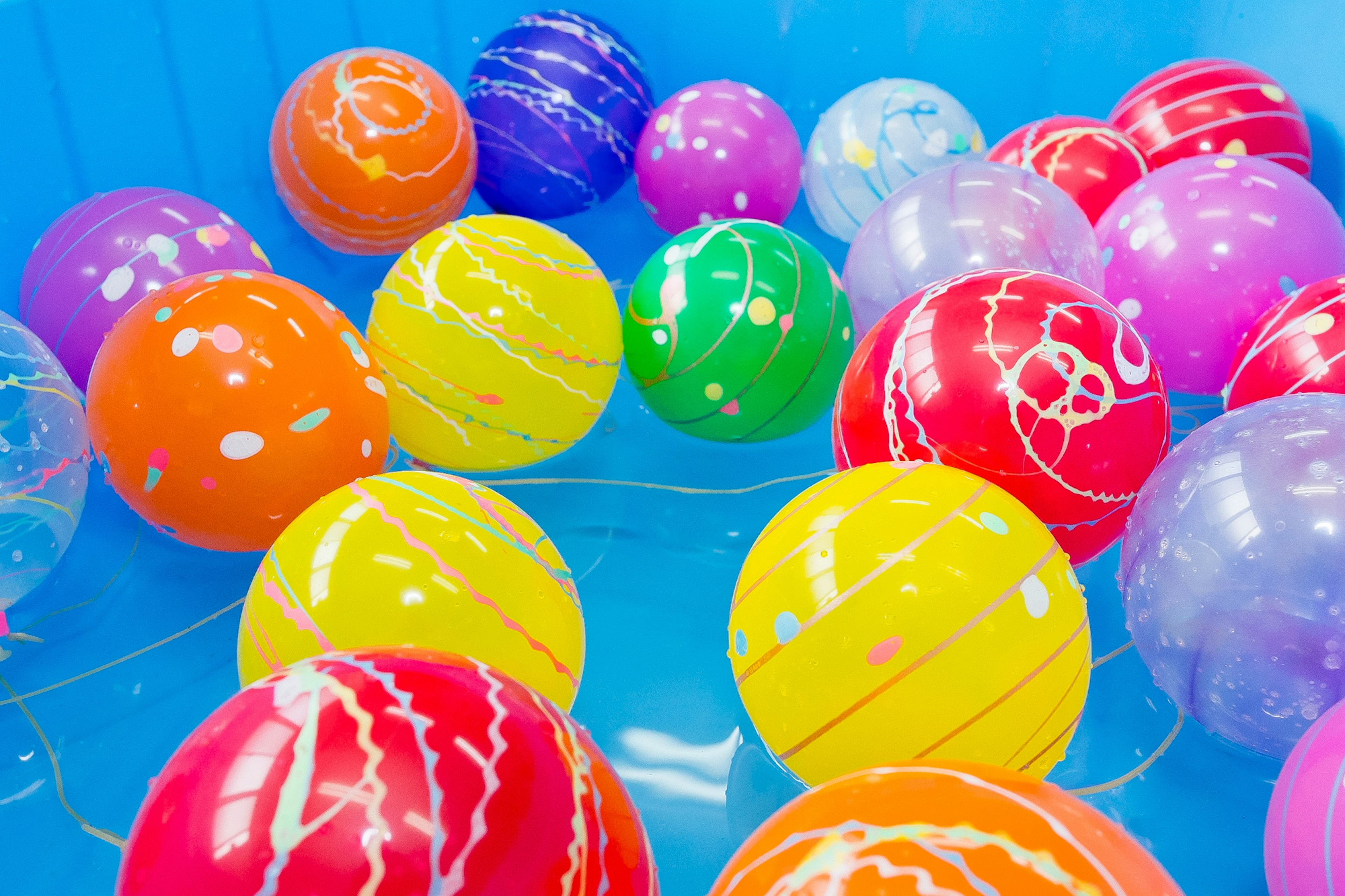 Des balles colorées éparpillées sur un fond bleu