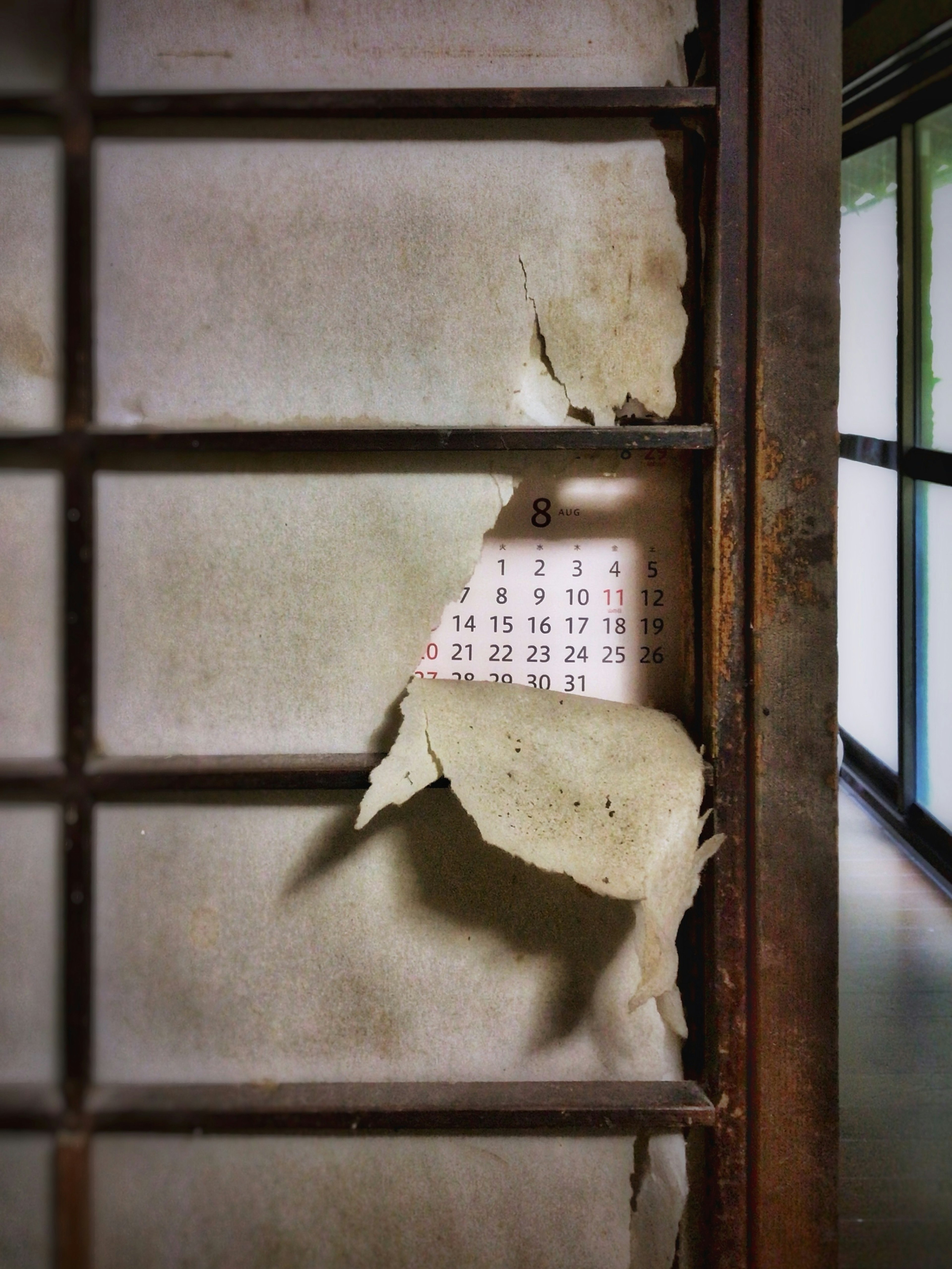 Peeling wall revealing a calendar behind it