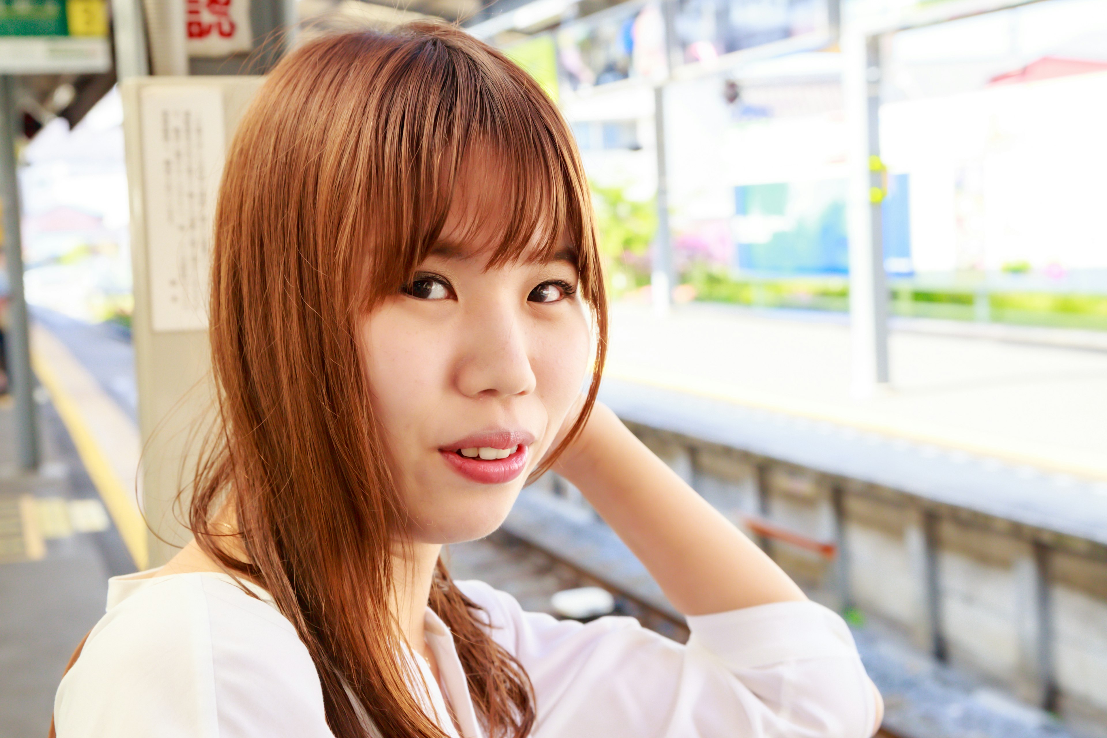 Portrait of a young woman smiling at a train station