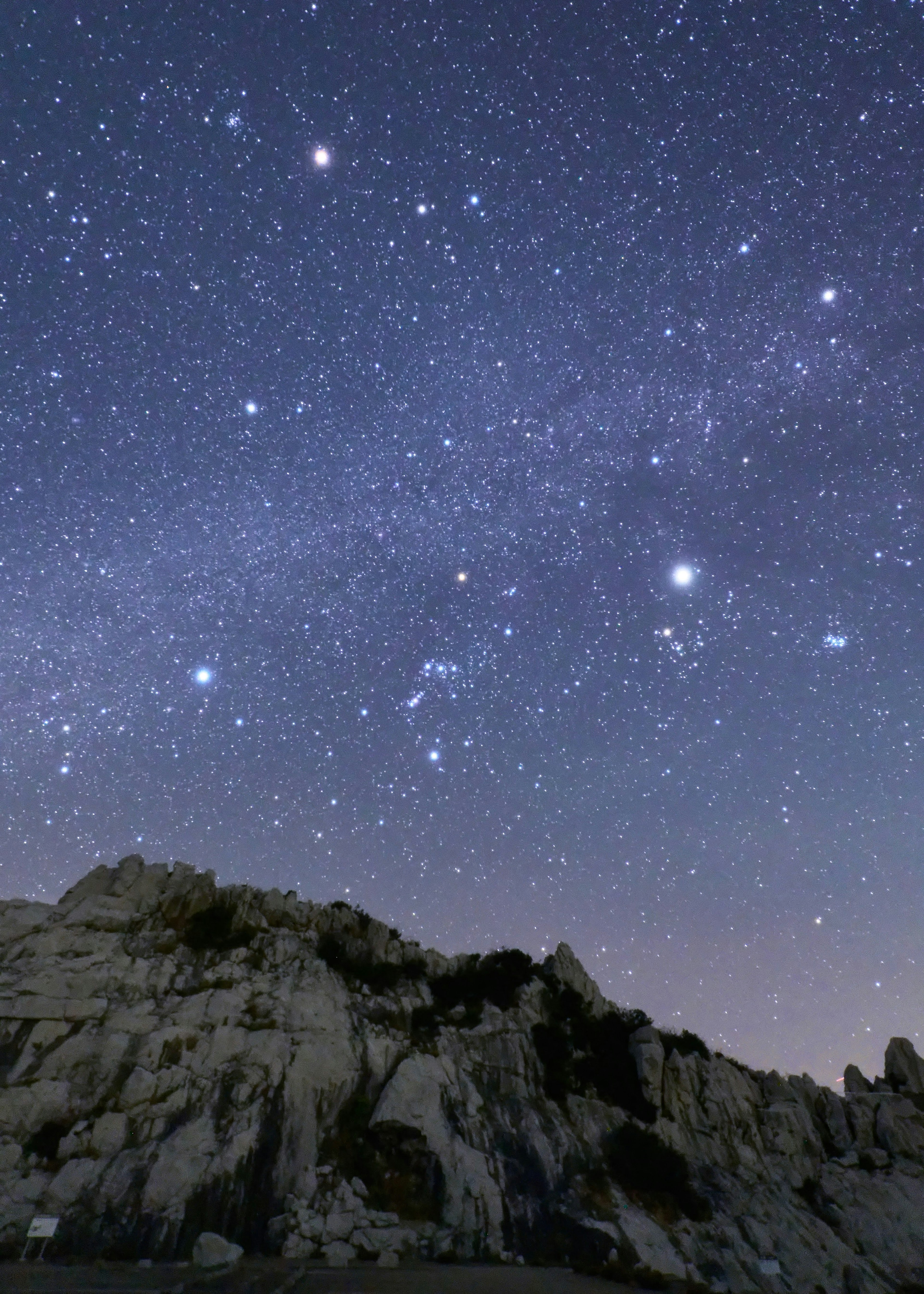 Cielo estrellado con siluetas de rocas