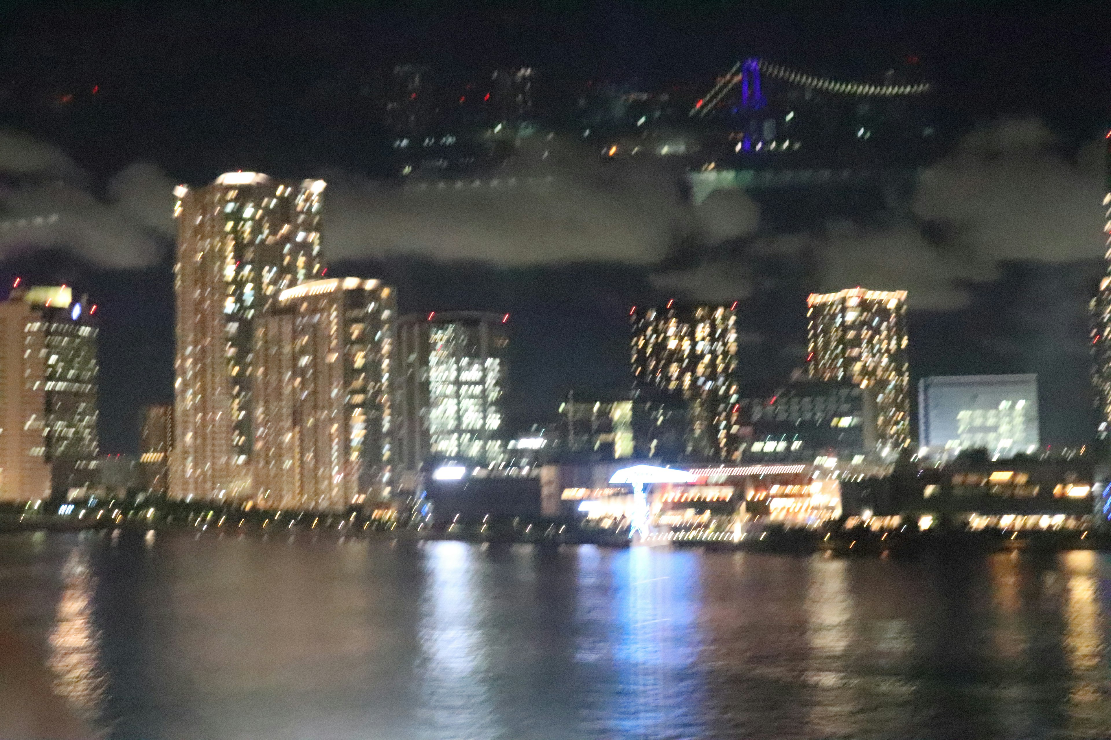 Paisaje urbano nocturno con rascacielos iluminados a lo largo de una hermosa bahía