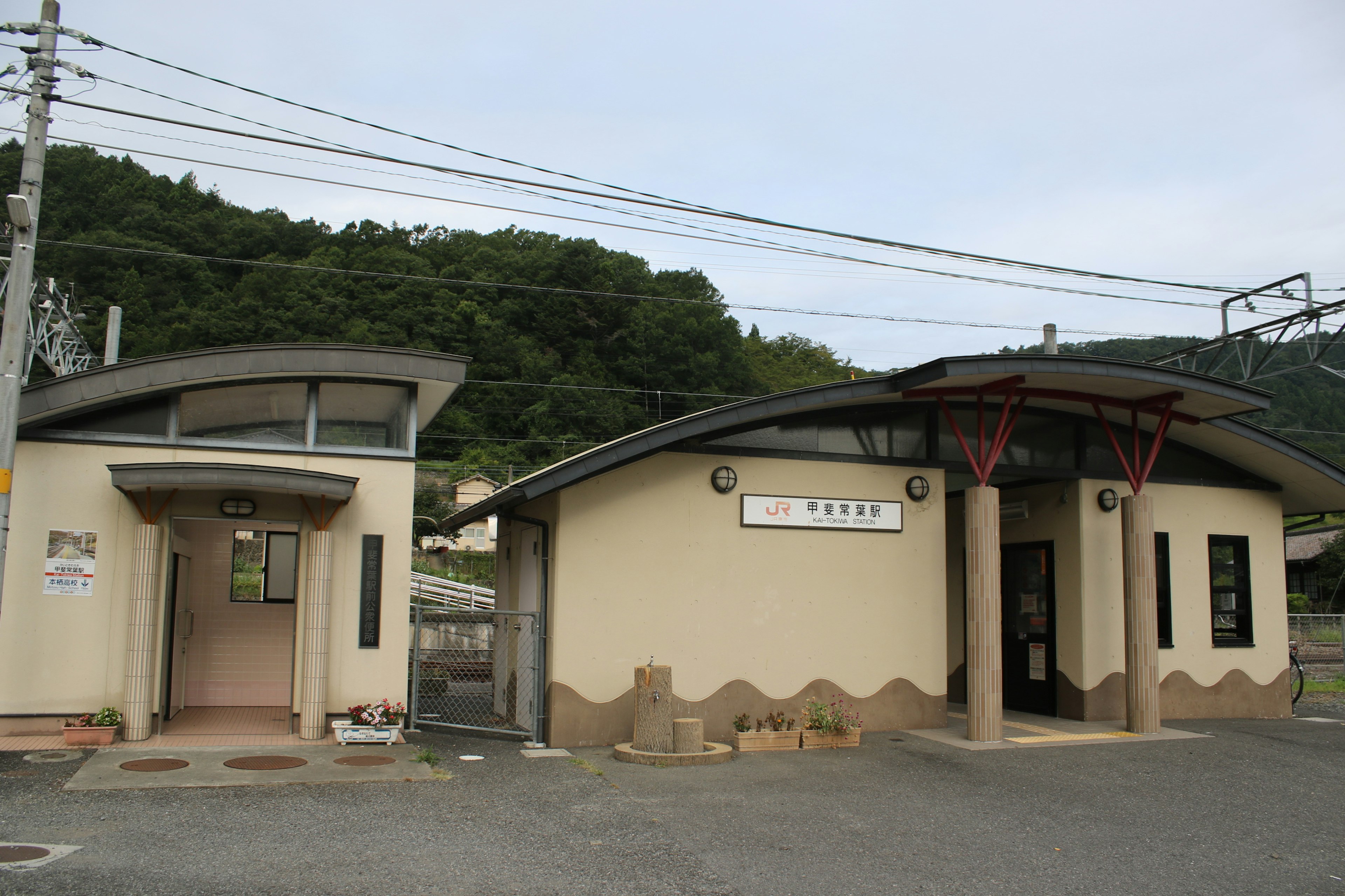 山の近くにある現代的な建物と伝統的なデザインの駅