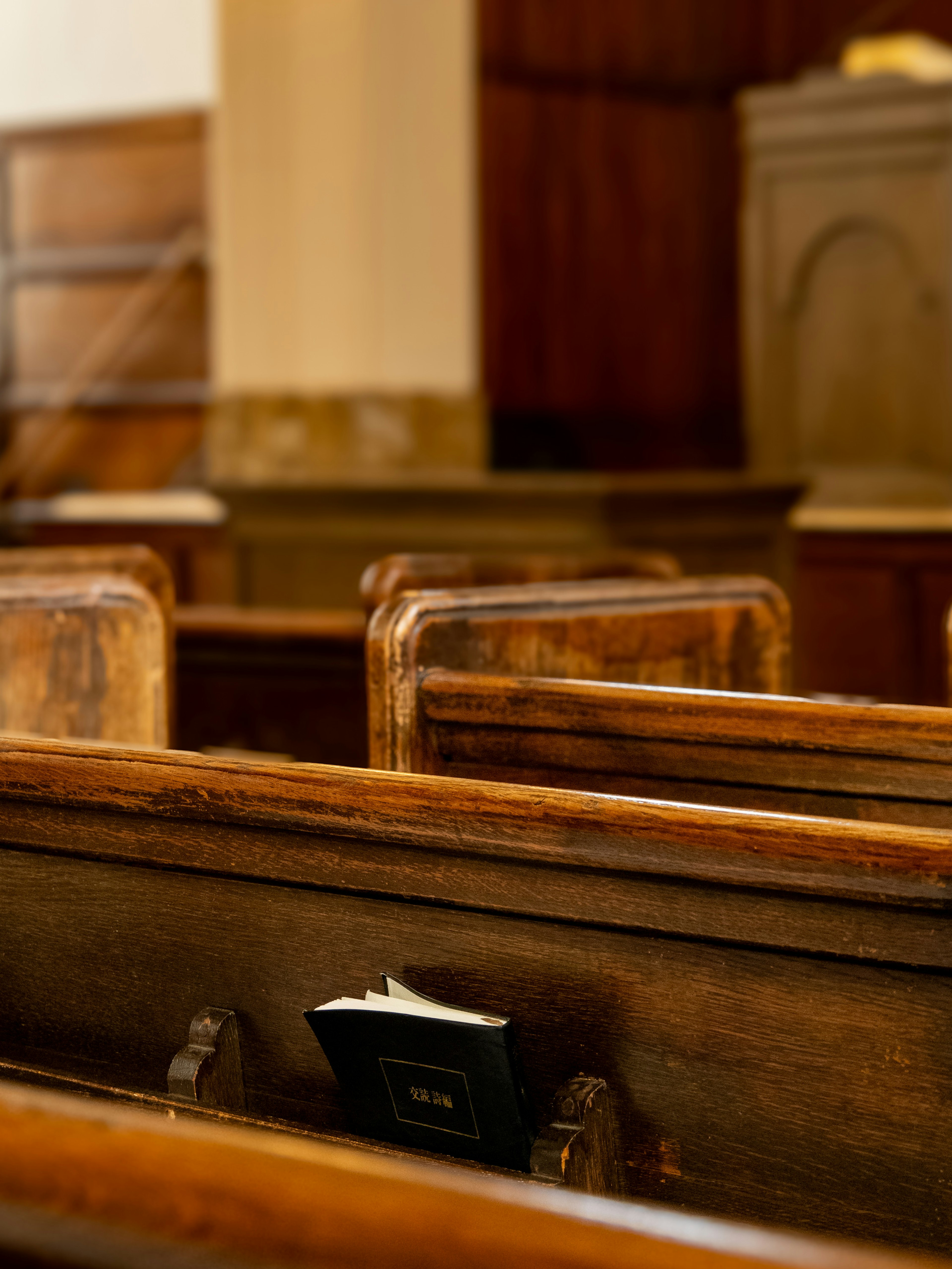 Wooden church pews with a Bible resting in one