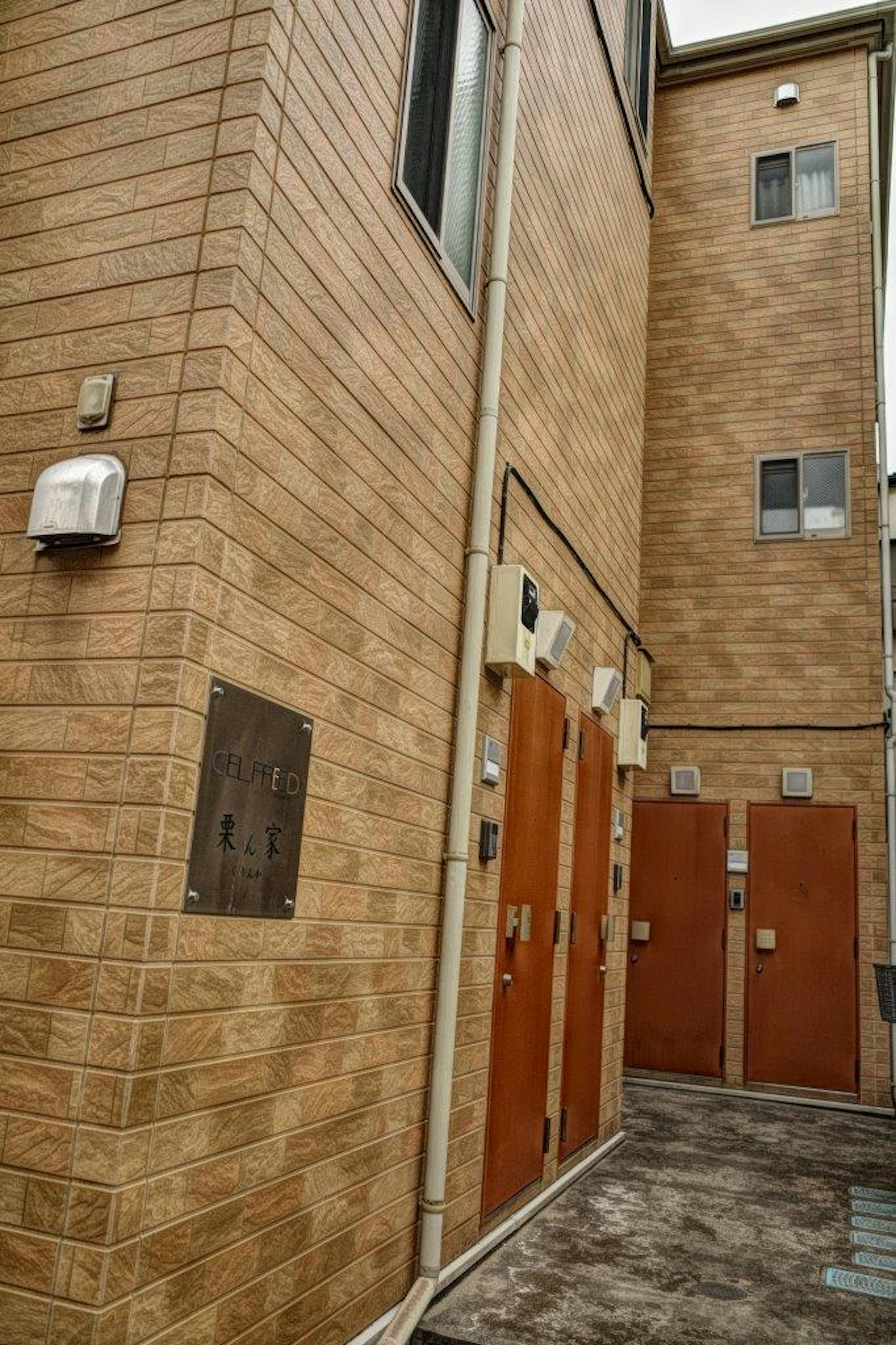 Narrow building exterior with wooden doors lined up