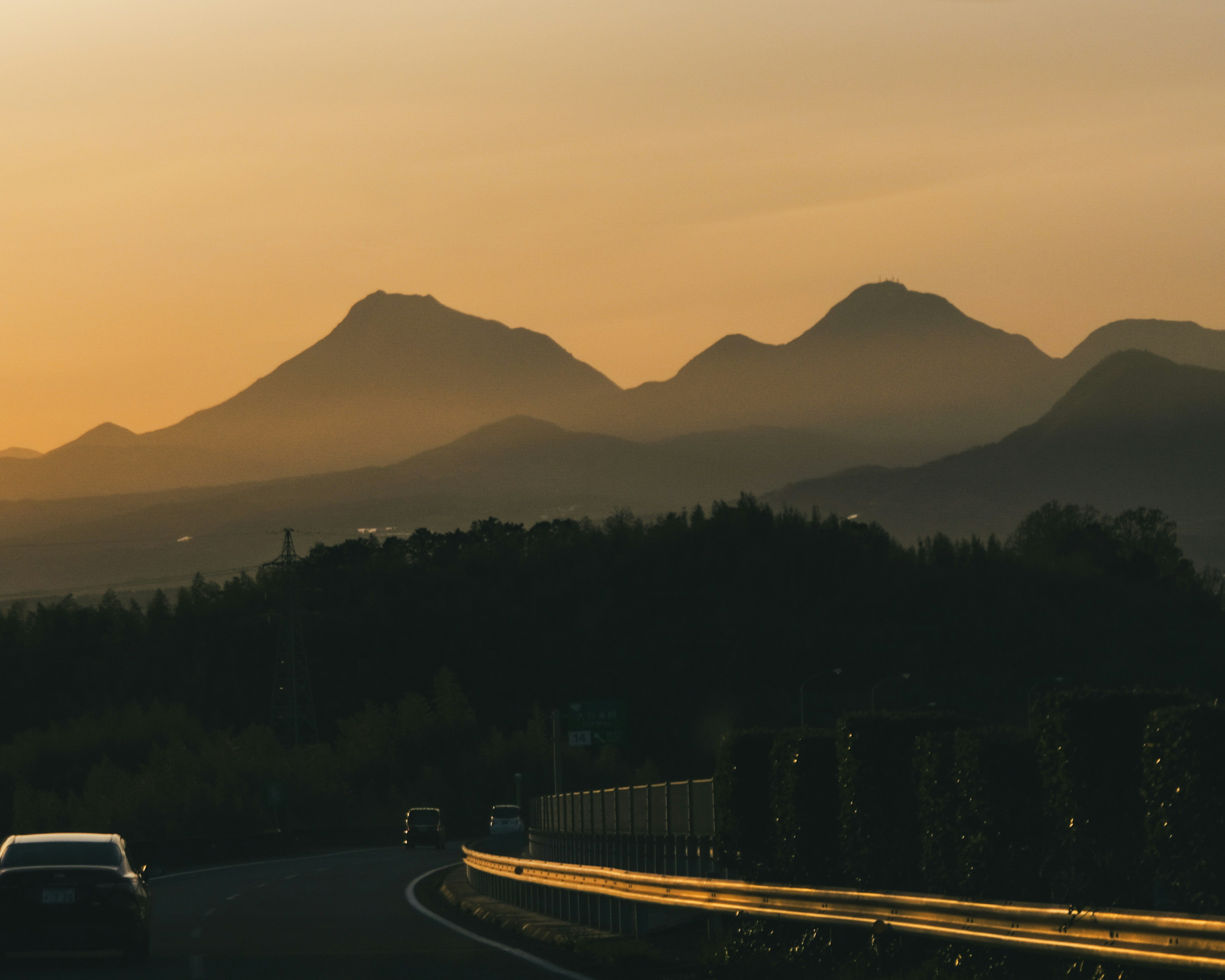 Vista escénica de montañas al atardecer con una carretera sinuosa