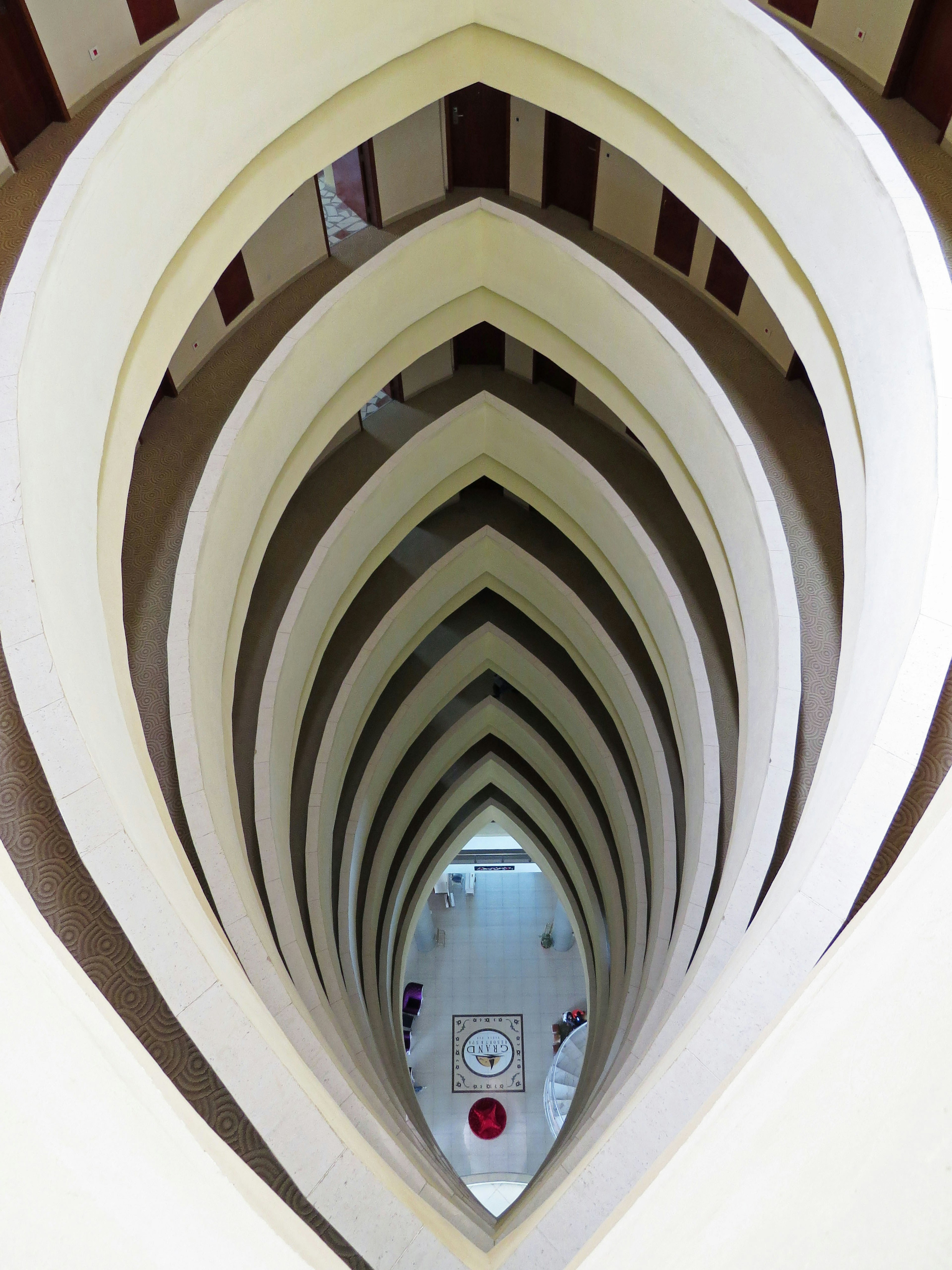 View looking down into a building featuring a series of white arches creating a unique perspective