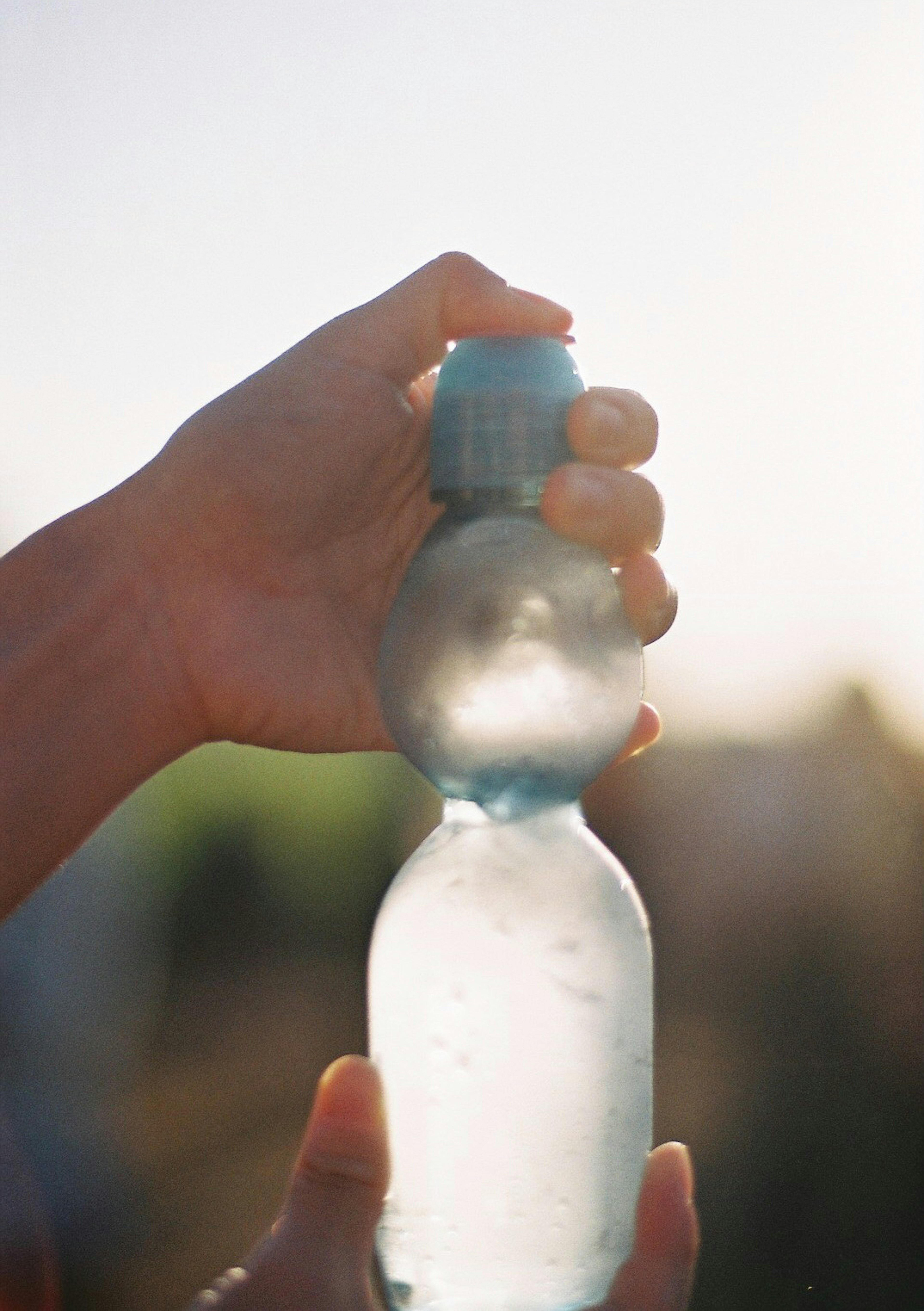 Une main appuyant sur le bouchon d'une bouteille d'eau