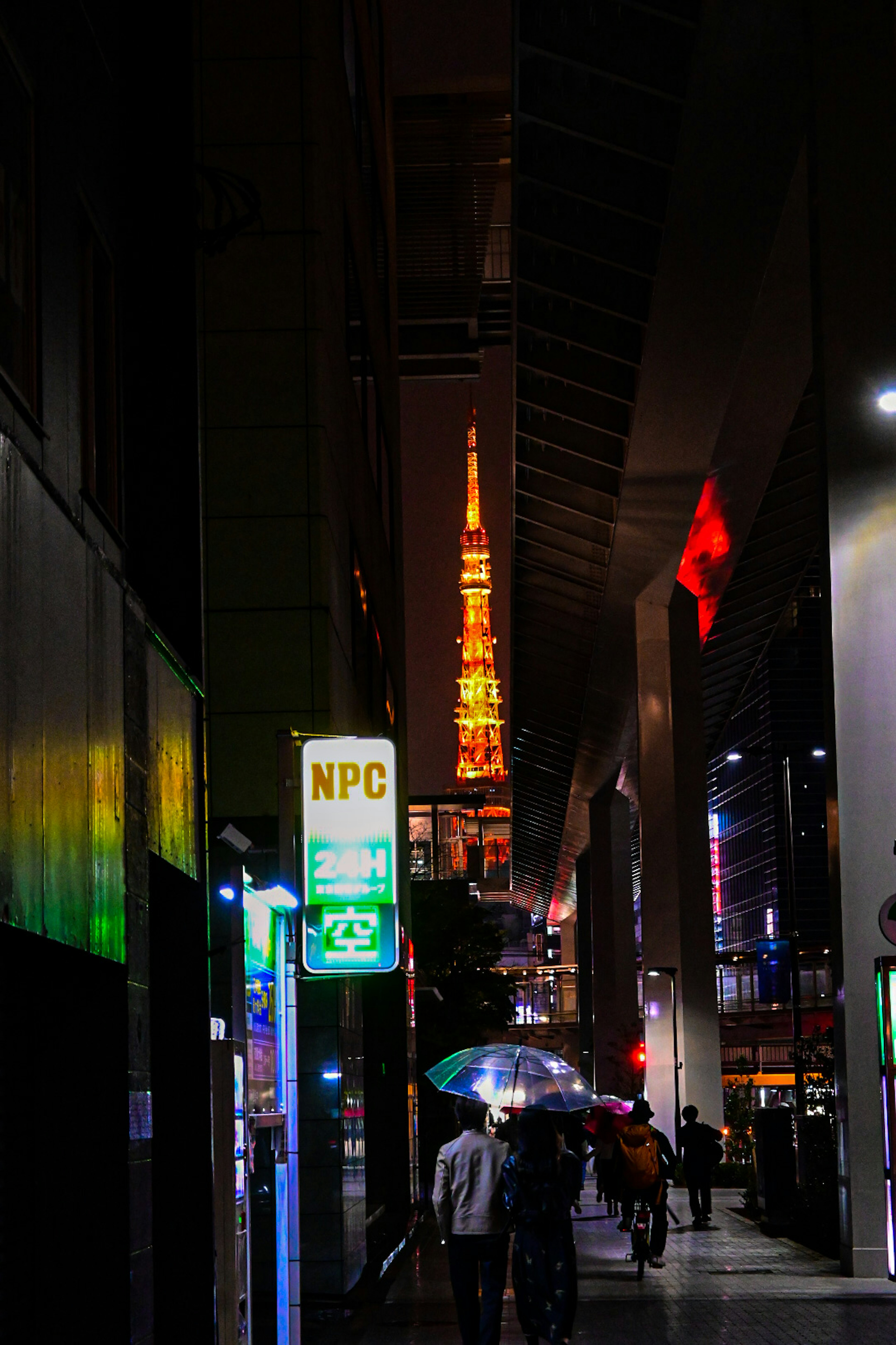 Vista notturna della Tokyo Tower con persone che camminano