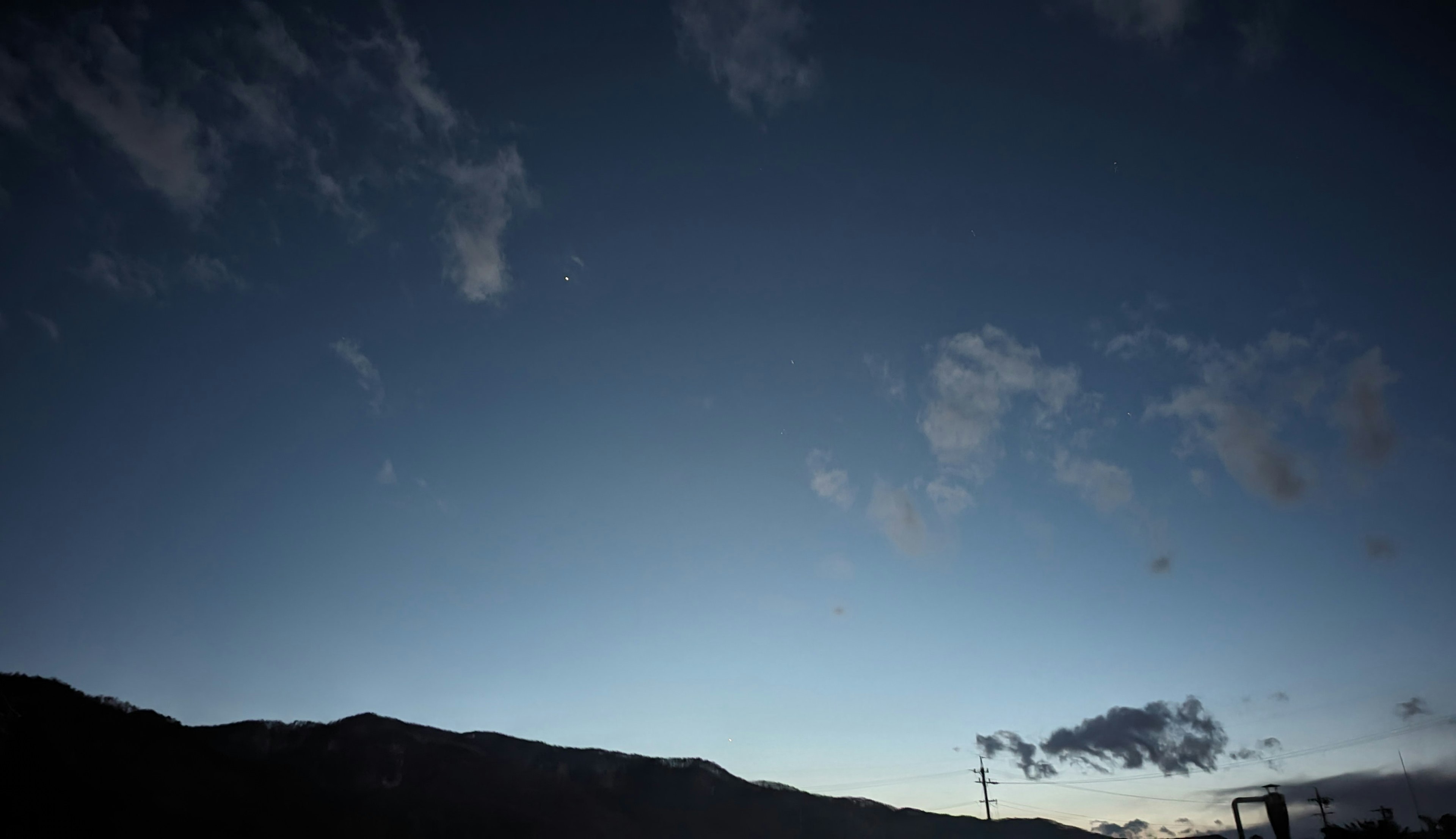 夜空に広がる青い色合いと雲が浮かぶ風景