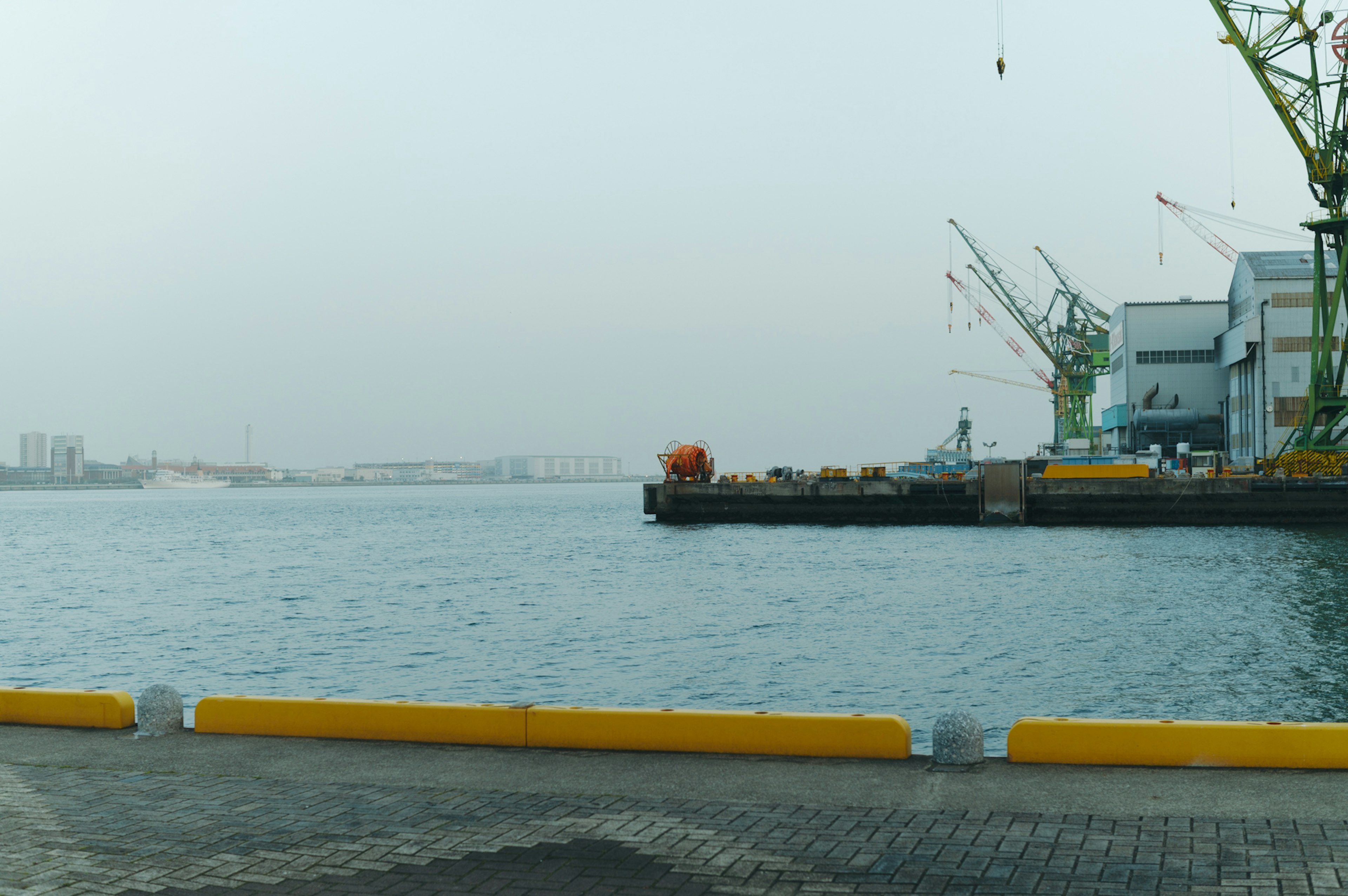 Harbor view with water and cranes in the background