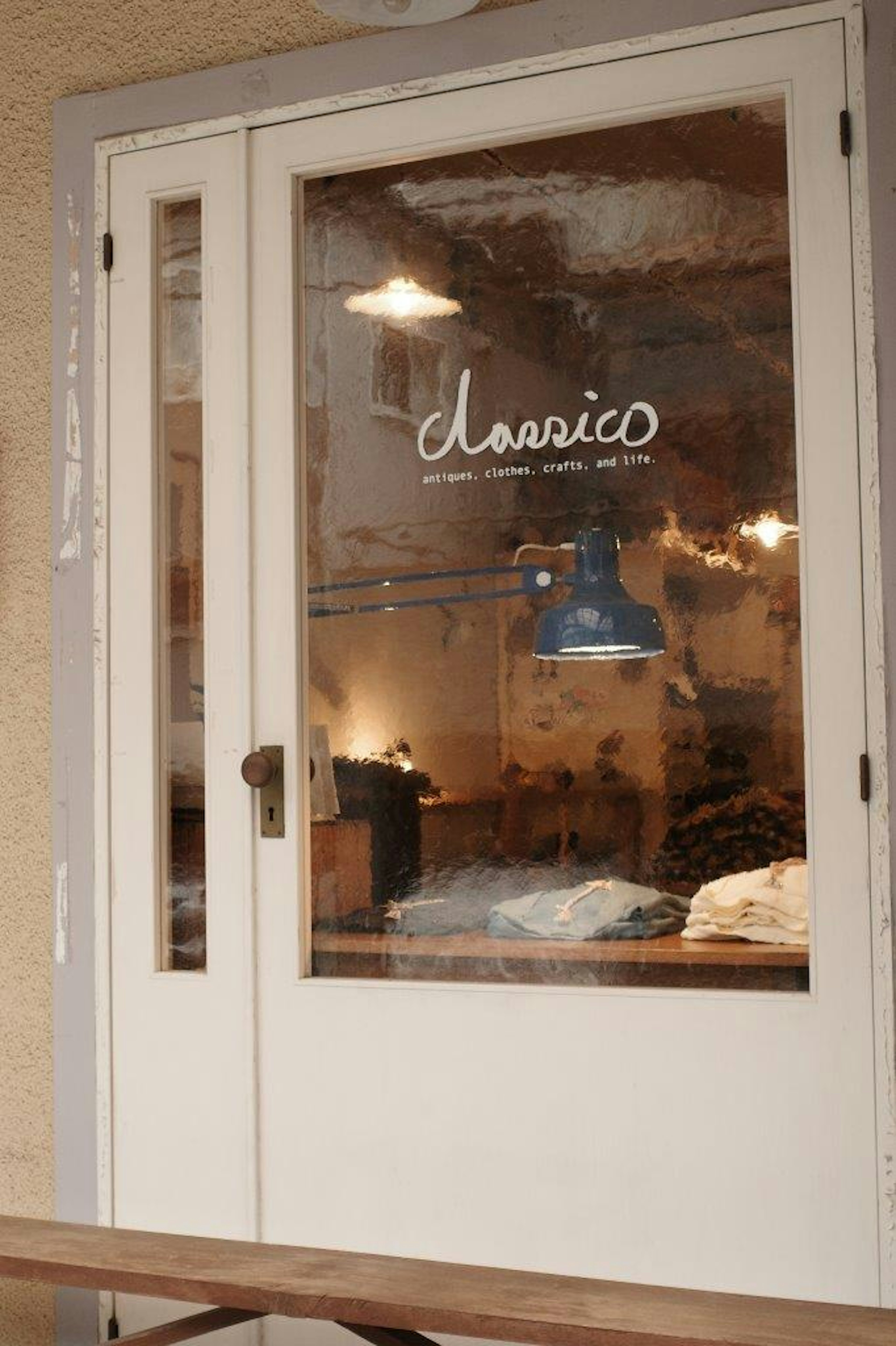 カフェの入口のガラスドアに青いランプと「classico」のロゴが見える