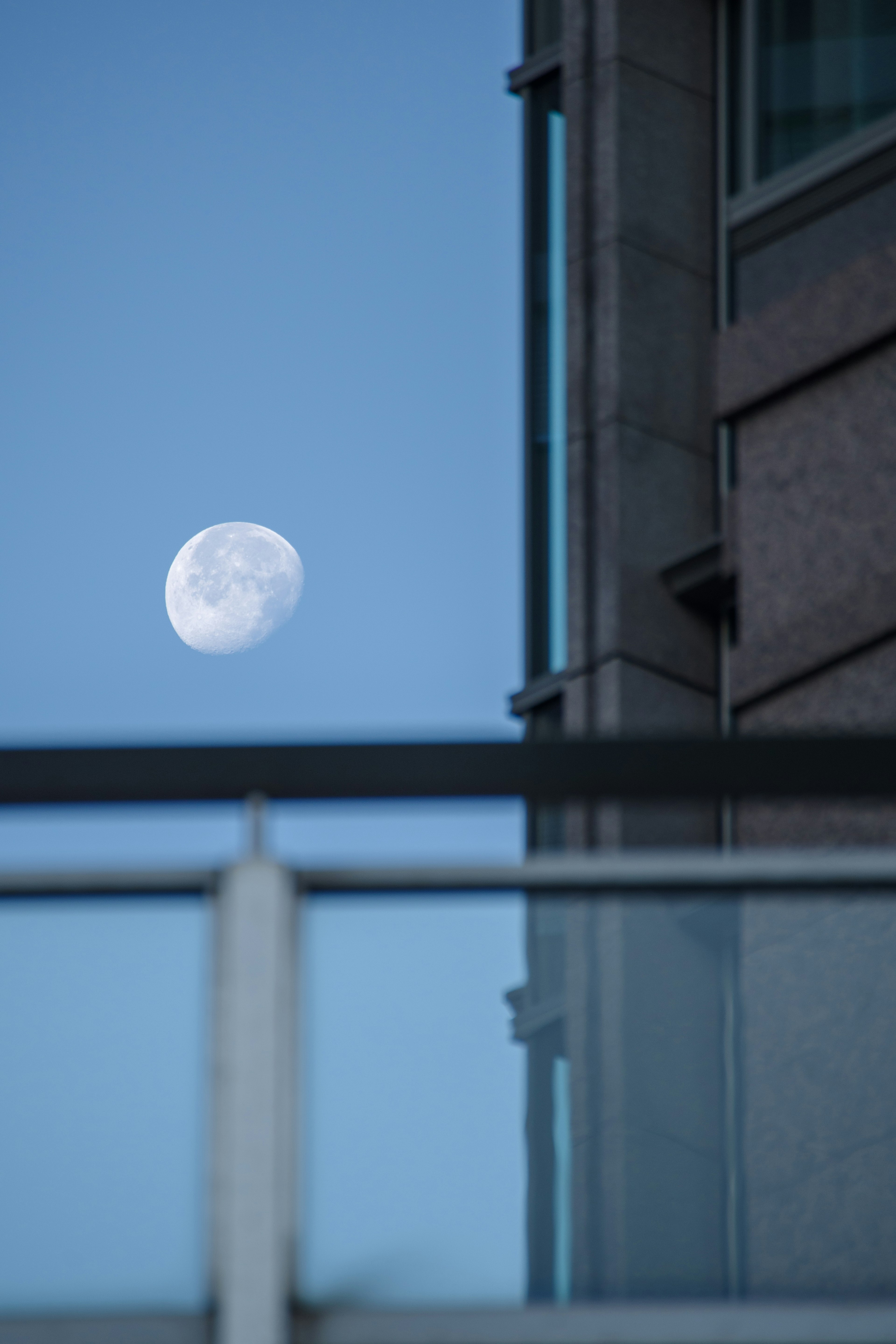 Pemandangan dengan bulan di langit biru dan bagian bangunan terlihat