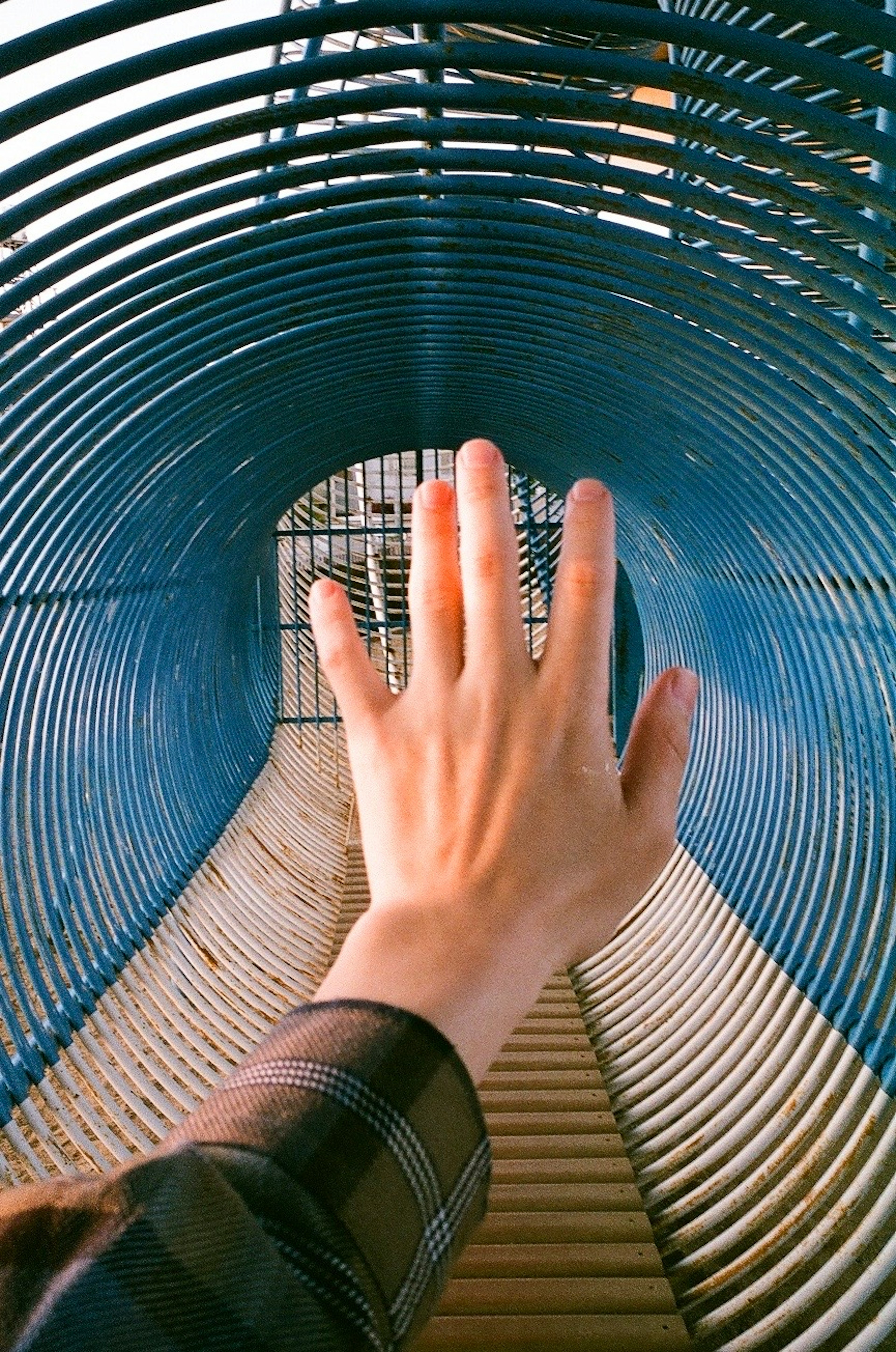 A hand reaching into a blue tunnel structure