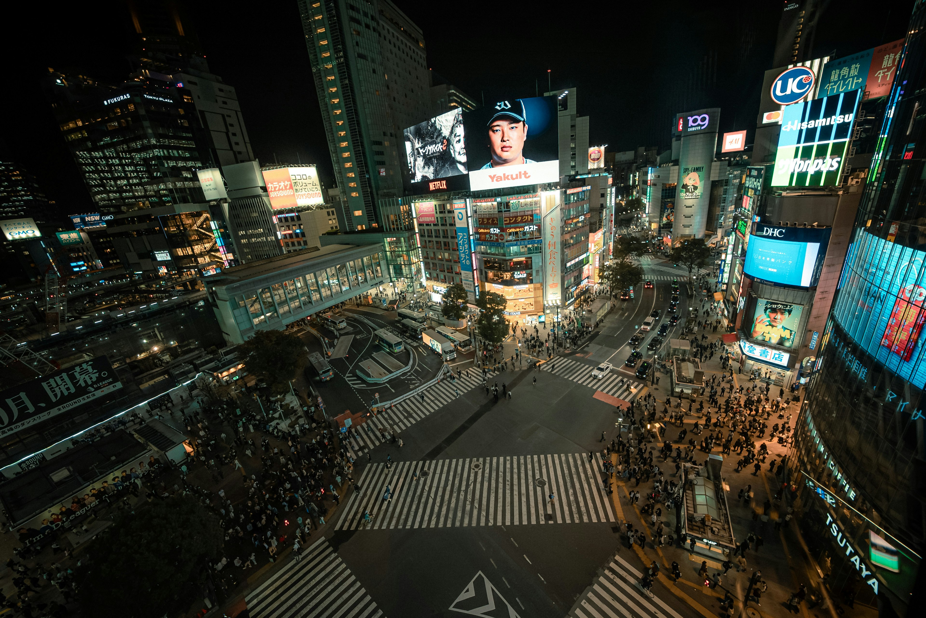 Shibuya intersection at night with neon signs