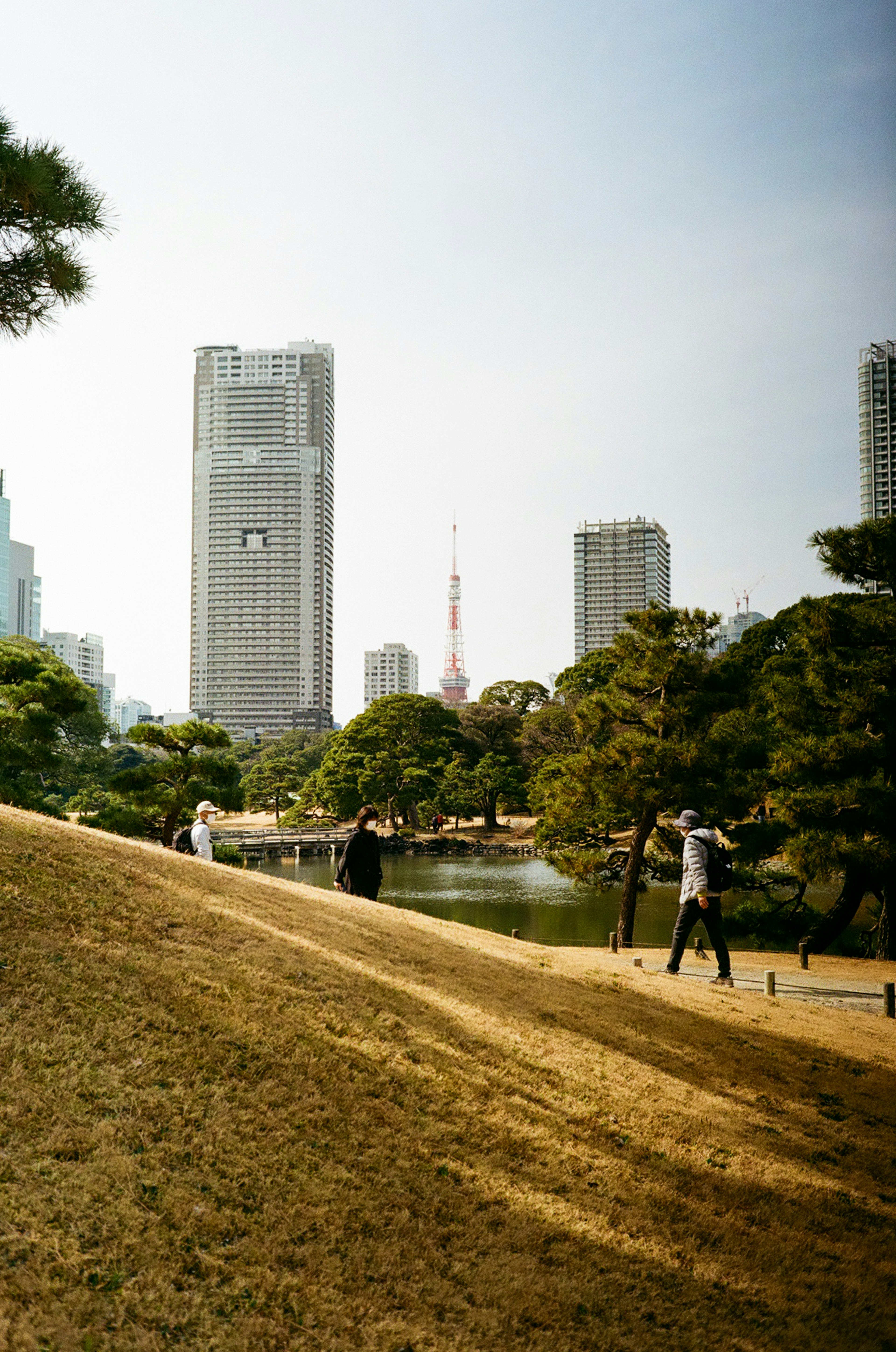 Pemandangan taman kota dengan gedung pencakar langit dan Menara Tokyo pohon hijau dan orang-orang berjalan