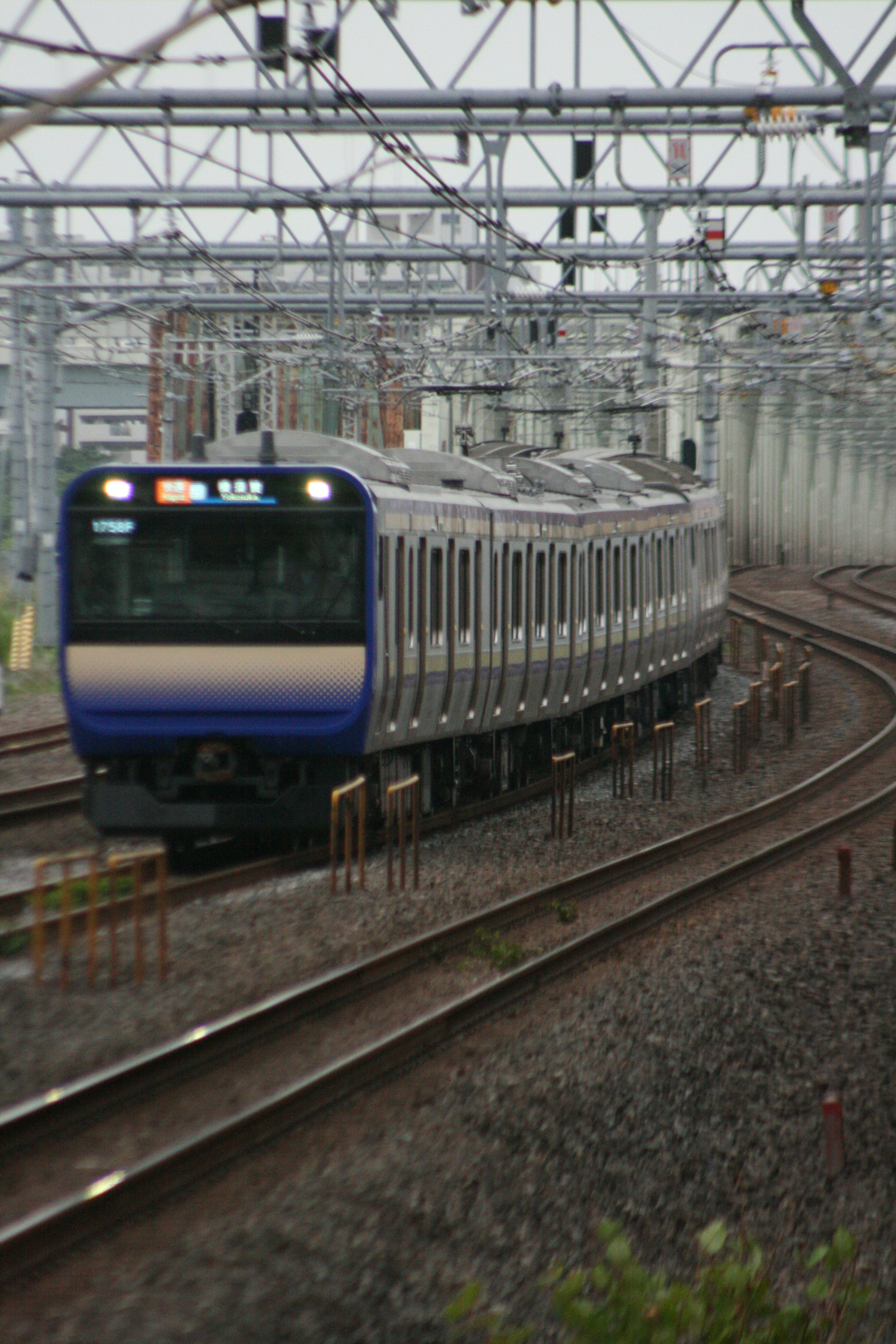 Tren azul girando en una curva sobre rieles