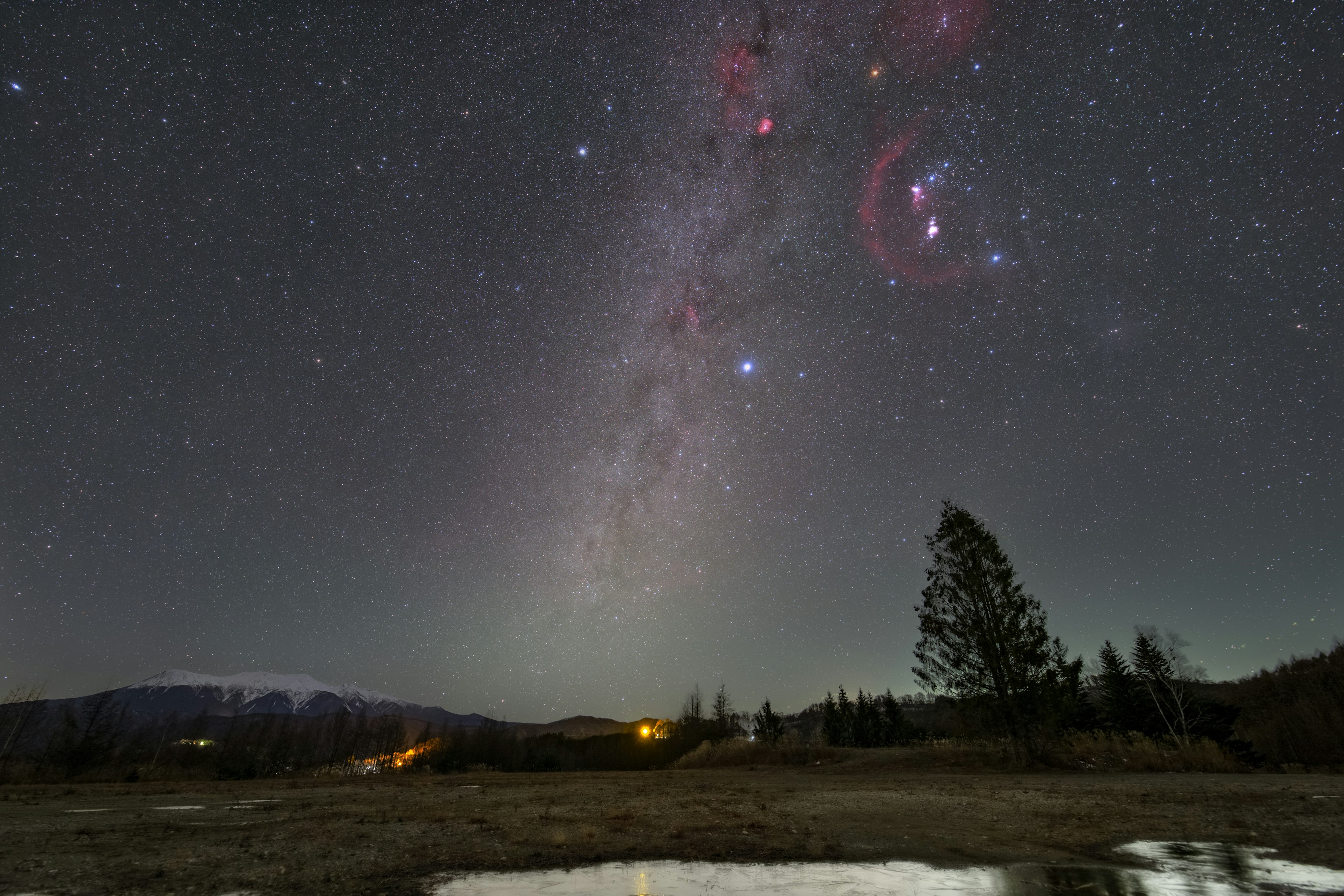 星空の下に広がる銀河系の眺めと水たまりの反射